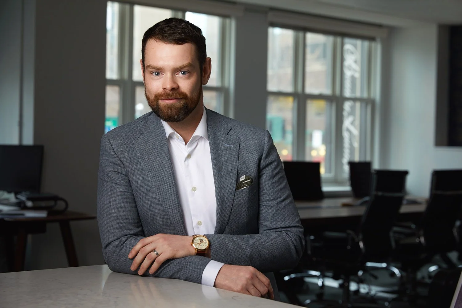 Office portrait at a white table, grey jacket