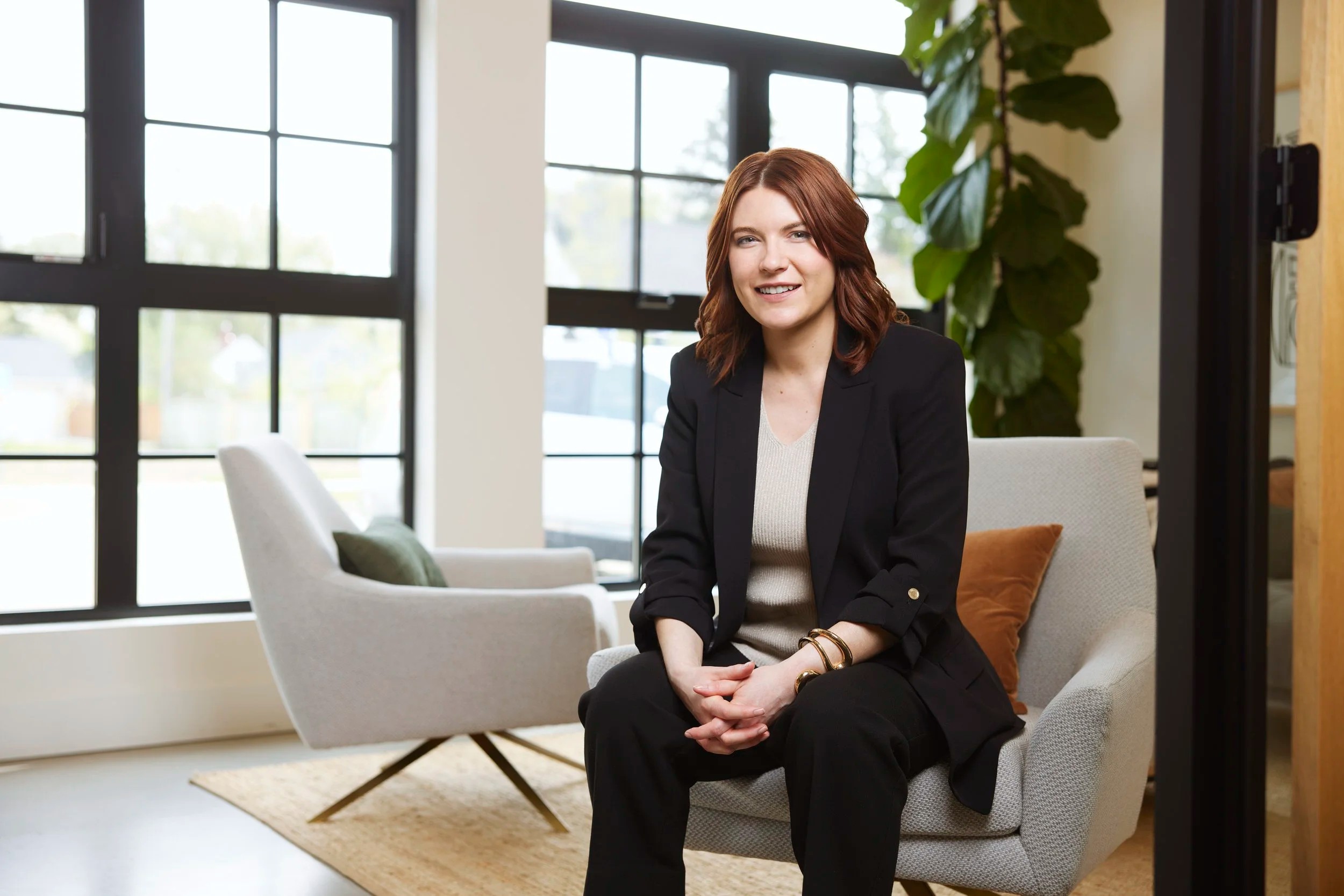 Office portrait in an armchair by tall windows