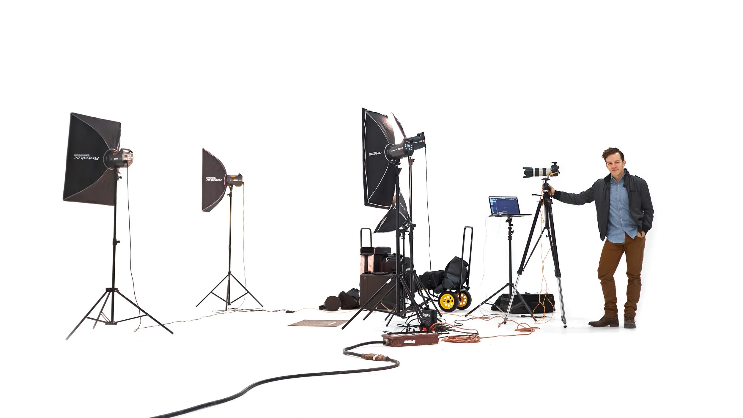 Ryan beside the kit that travels: three lights on stands, the camera, the cart and the cases