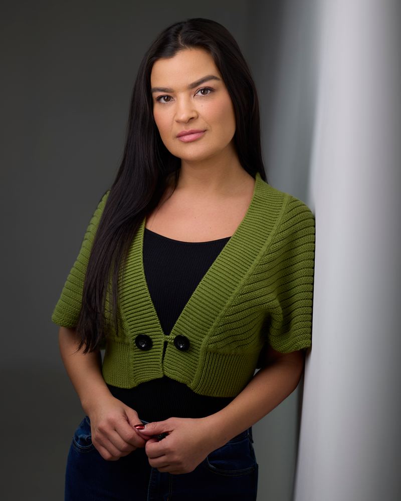 Crystle Lightning in a green cardigan, hands folded