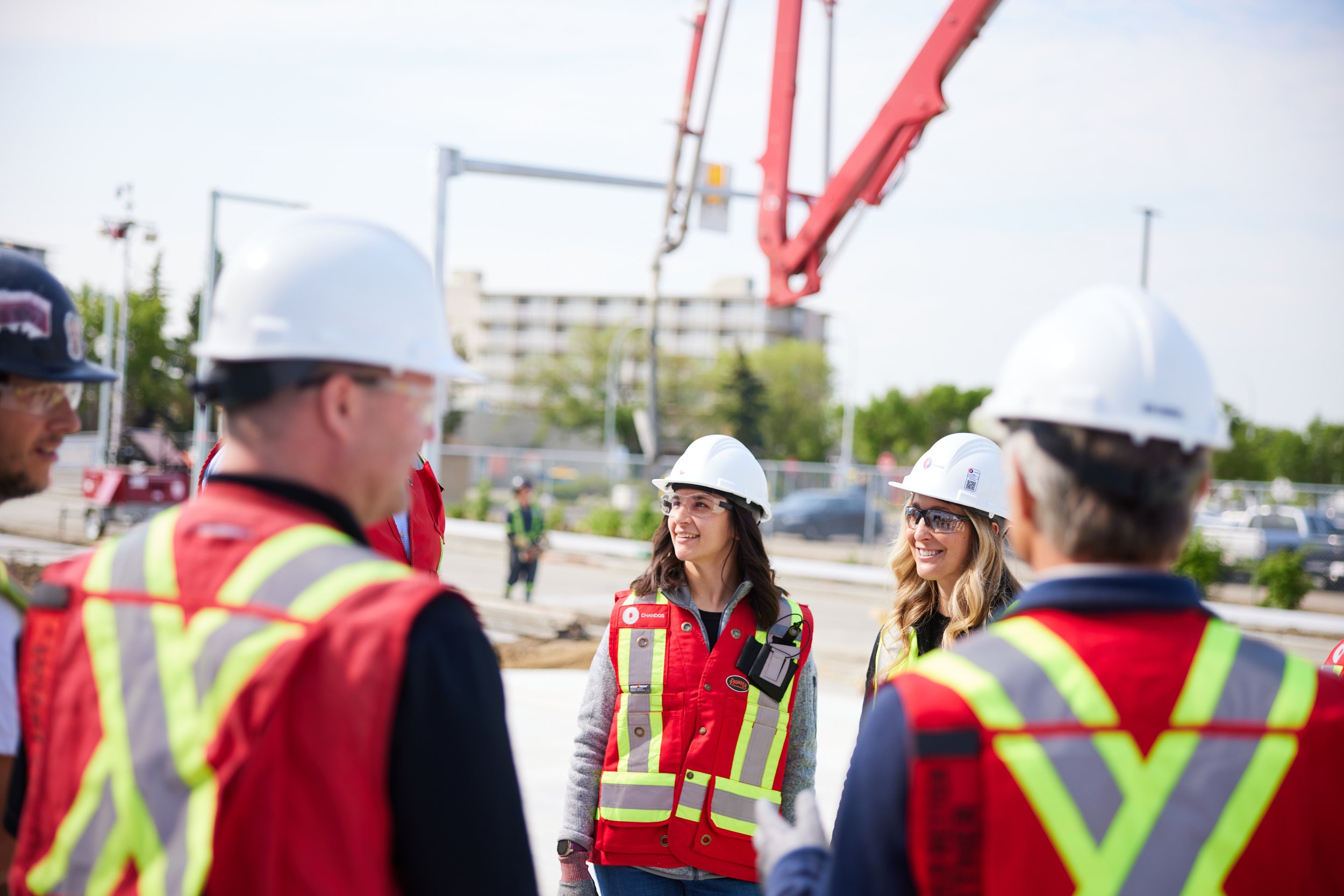 A group on site, a concrete pump behind them