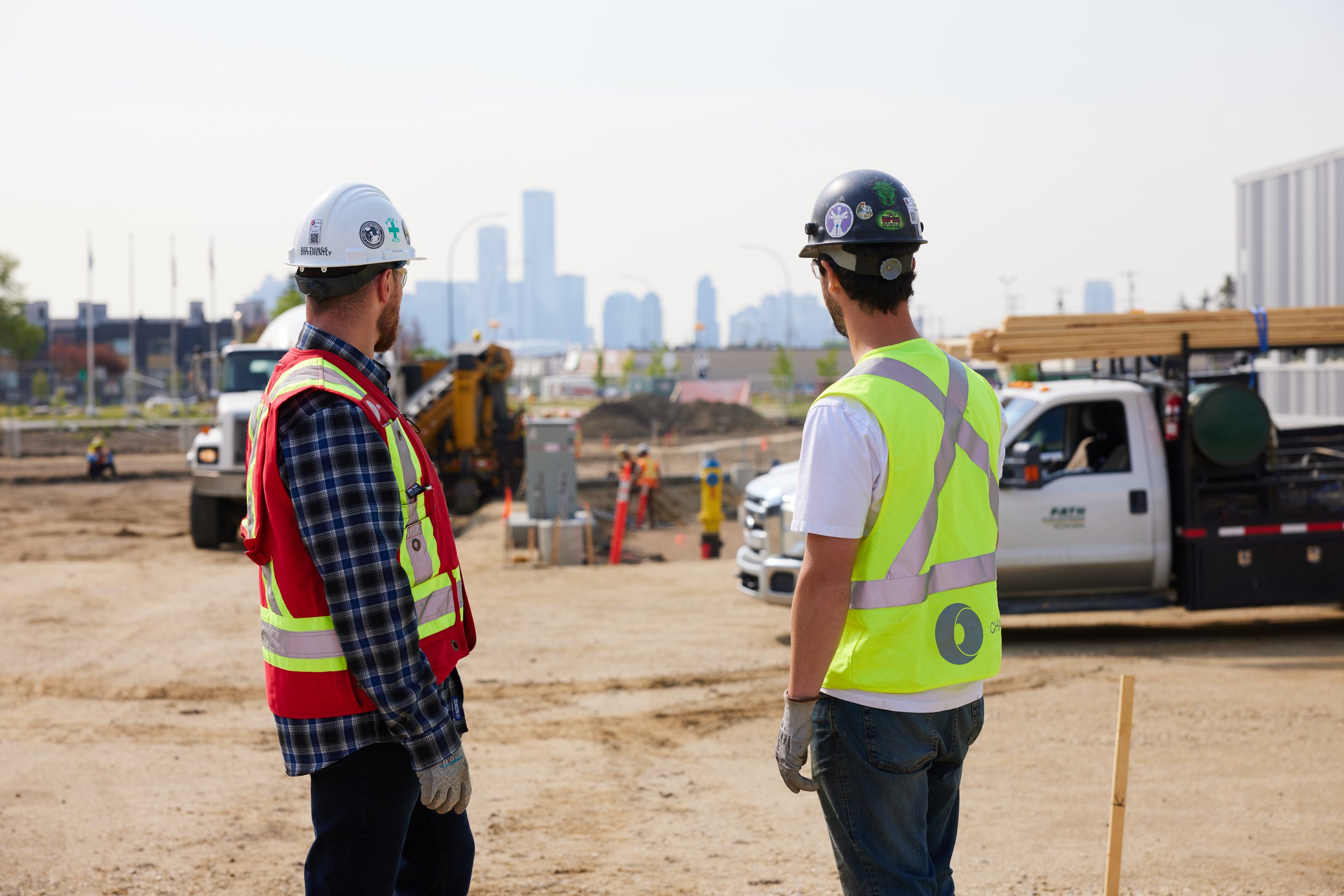 Two of the crew on site with the Edmonton skyline behind them