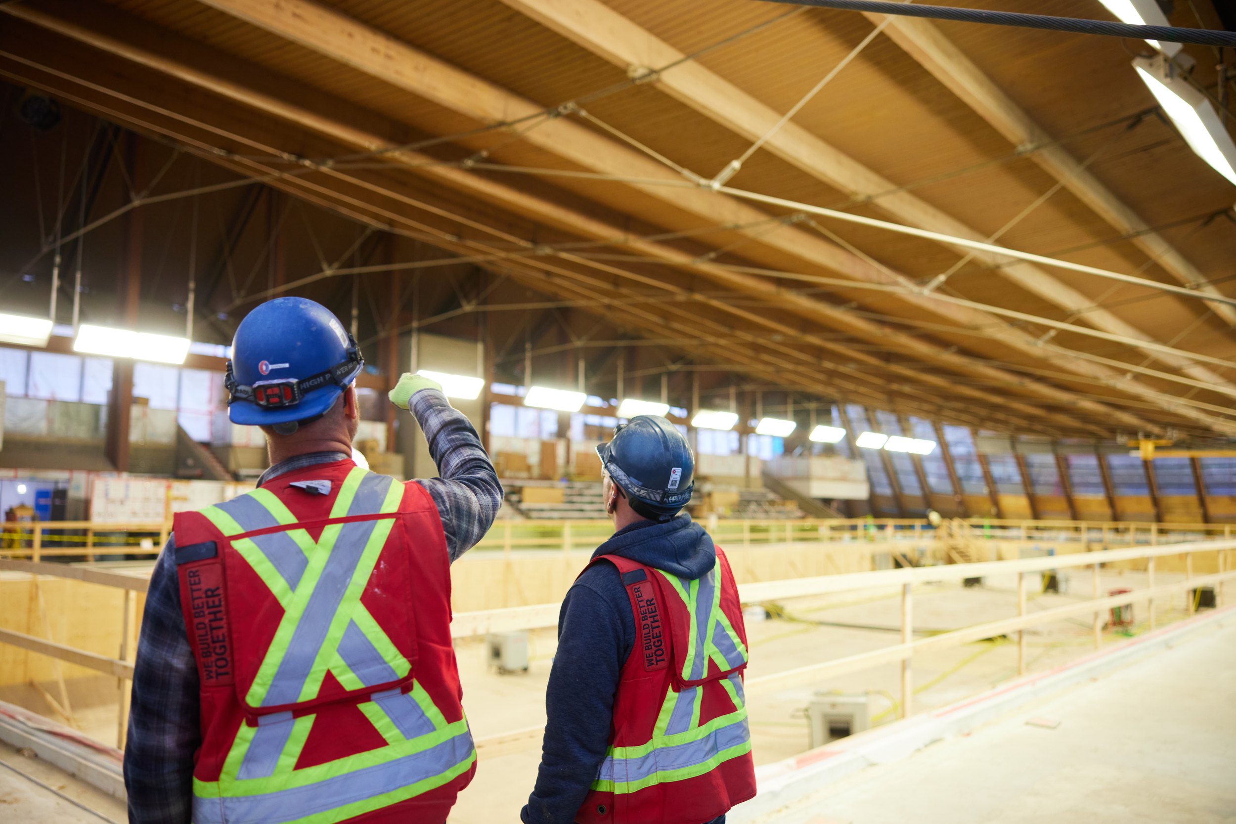 Two of the crew under a timber roof, one pointing up