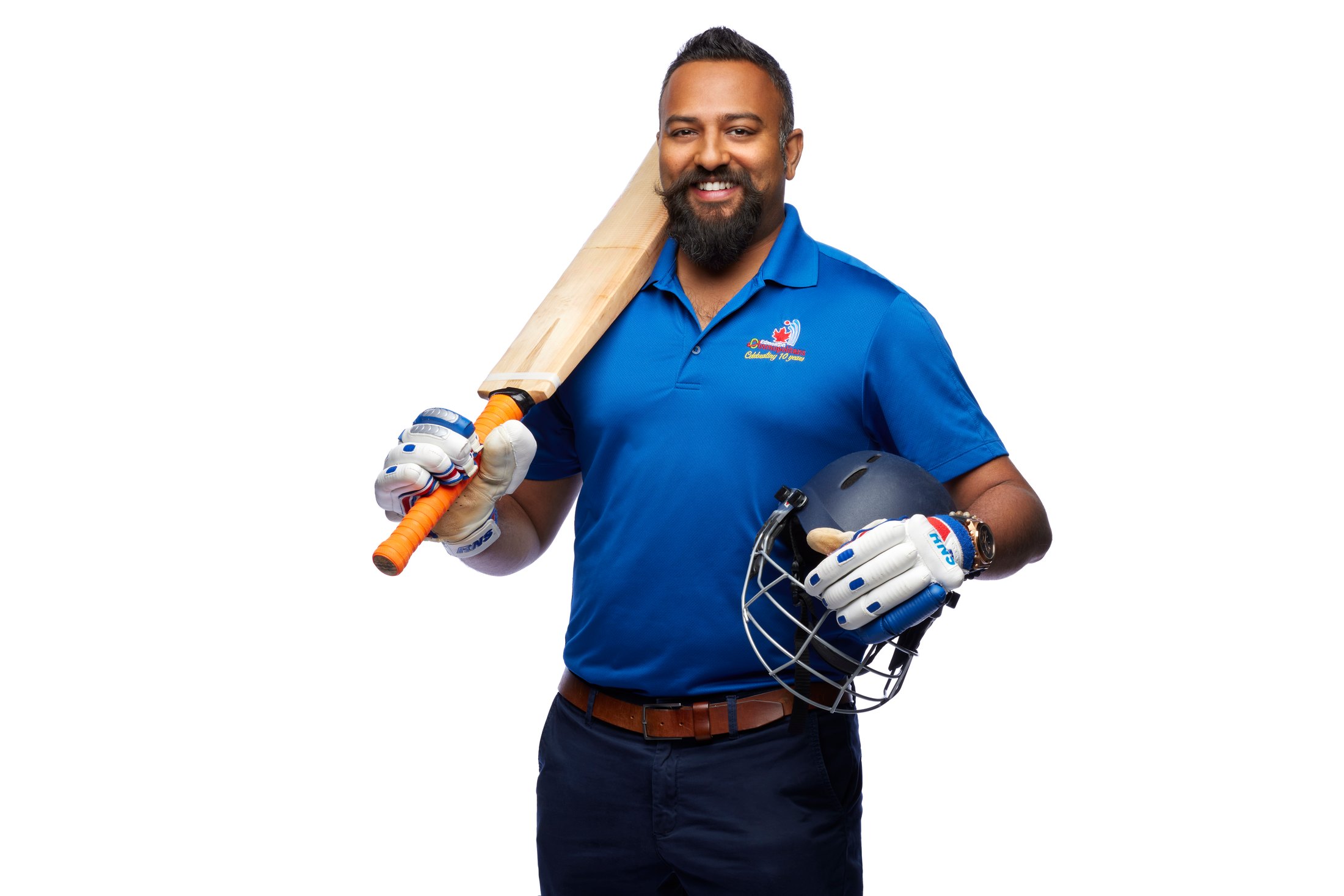 A cricket player with his bat over his shoulder and helmet in hand