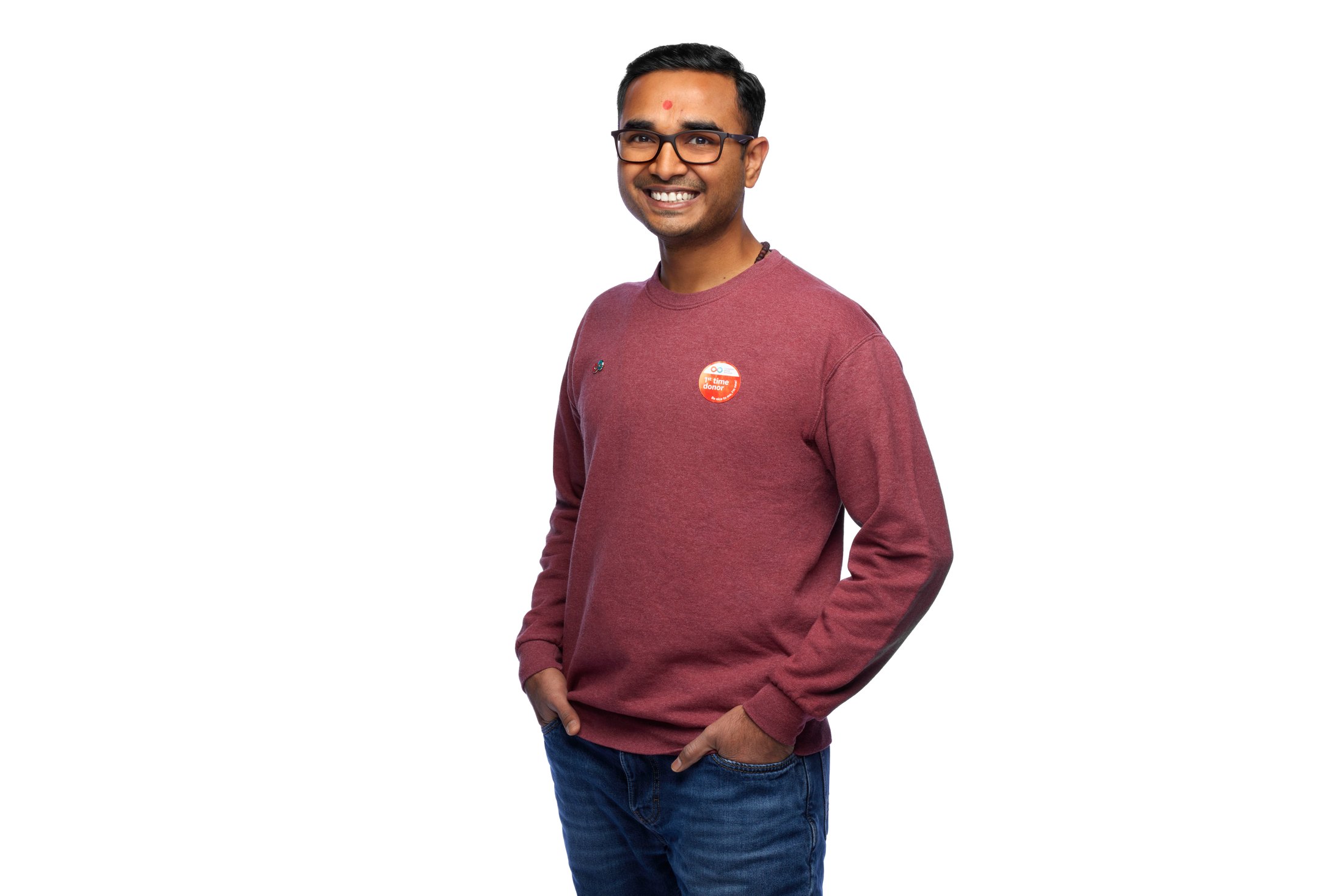 A man in a maroon sweatshirt, hands in his pockets