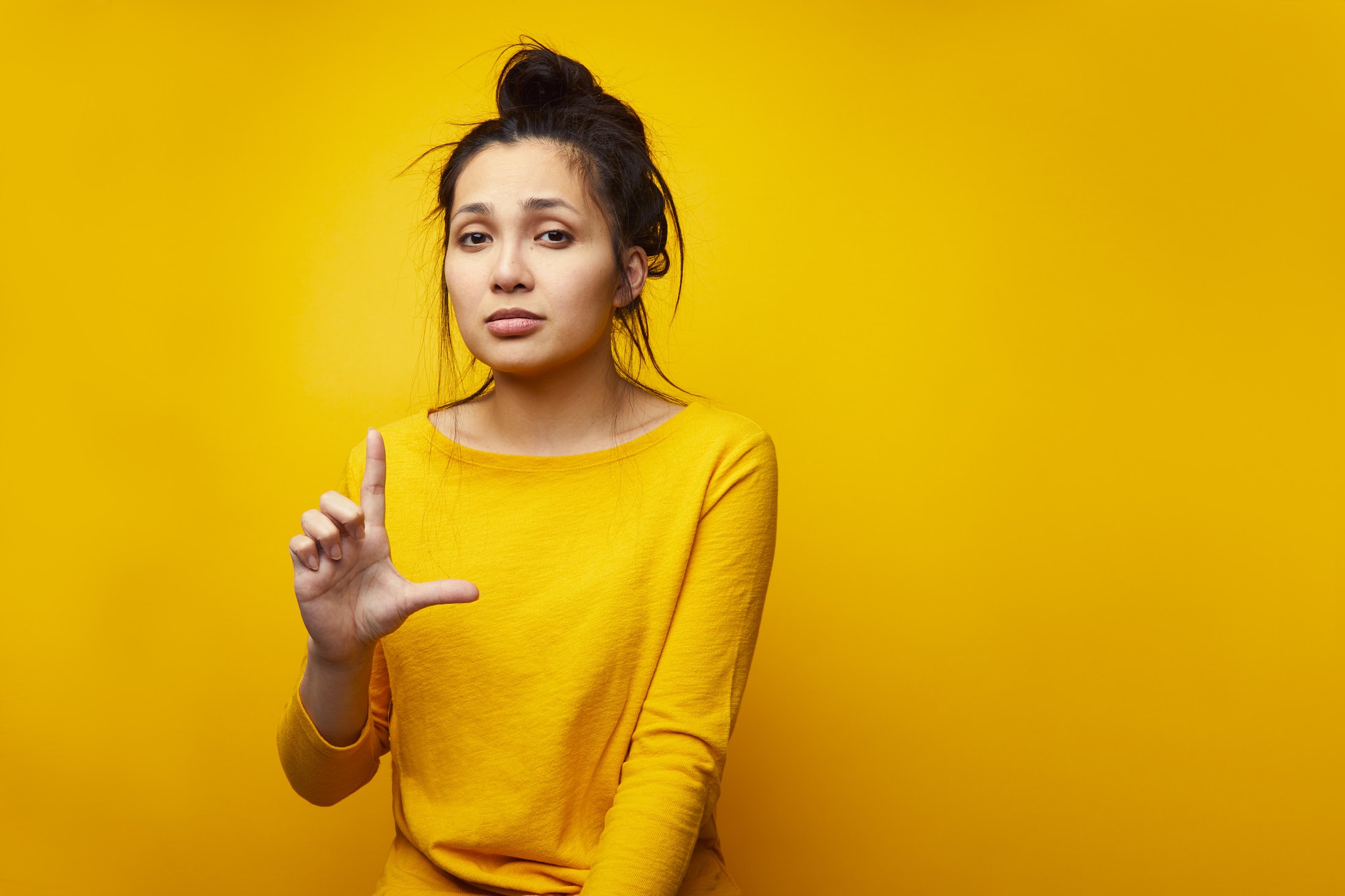The same performer against yellow, one finger raised