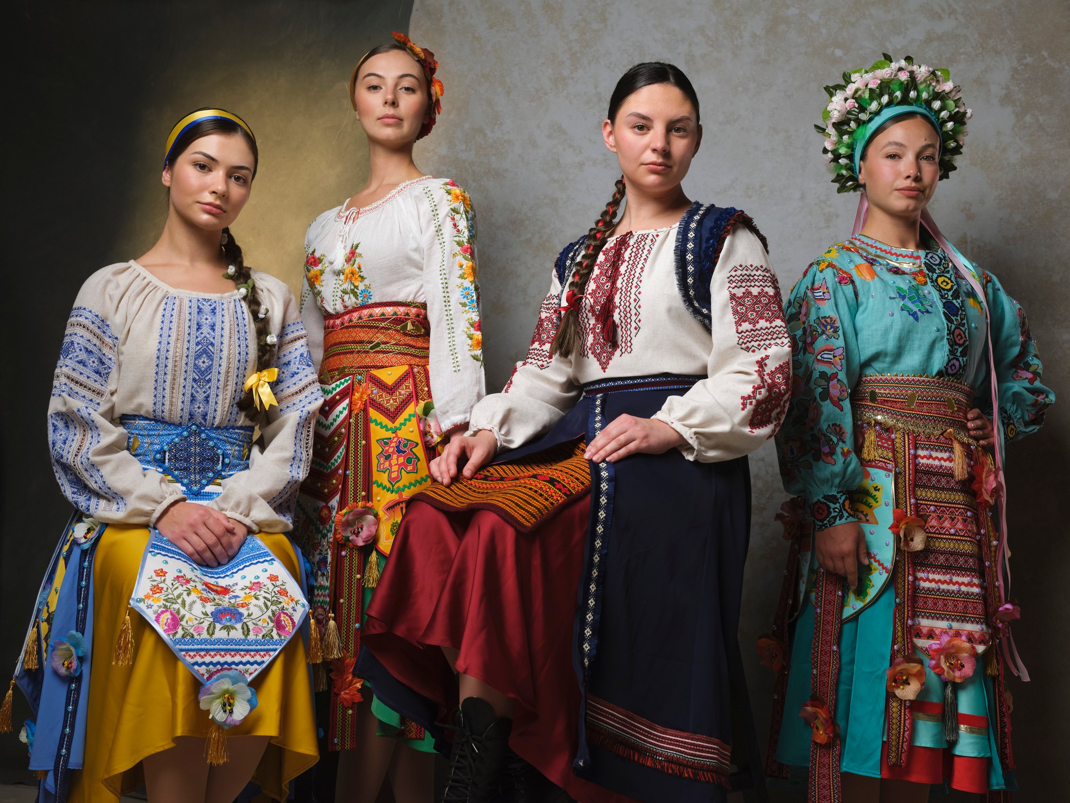 Shumka dancers together in Ukrainian costume against a painted backdrop