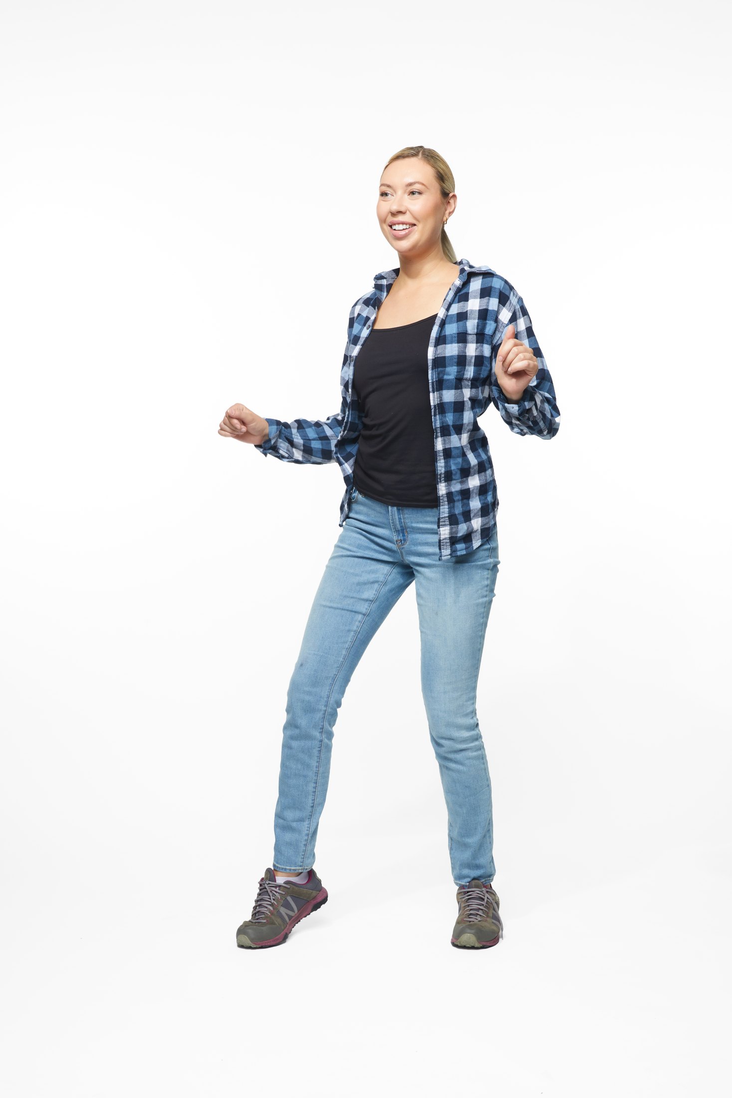 A woman in a plaid shirt and jeans in one of the program’s stretches, full length on white