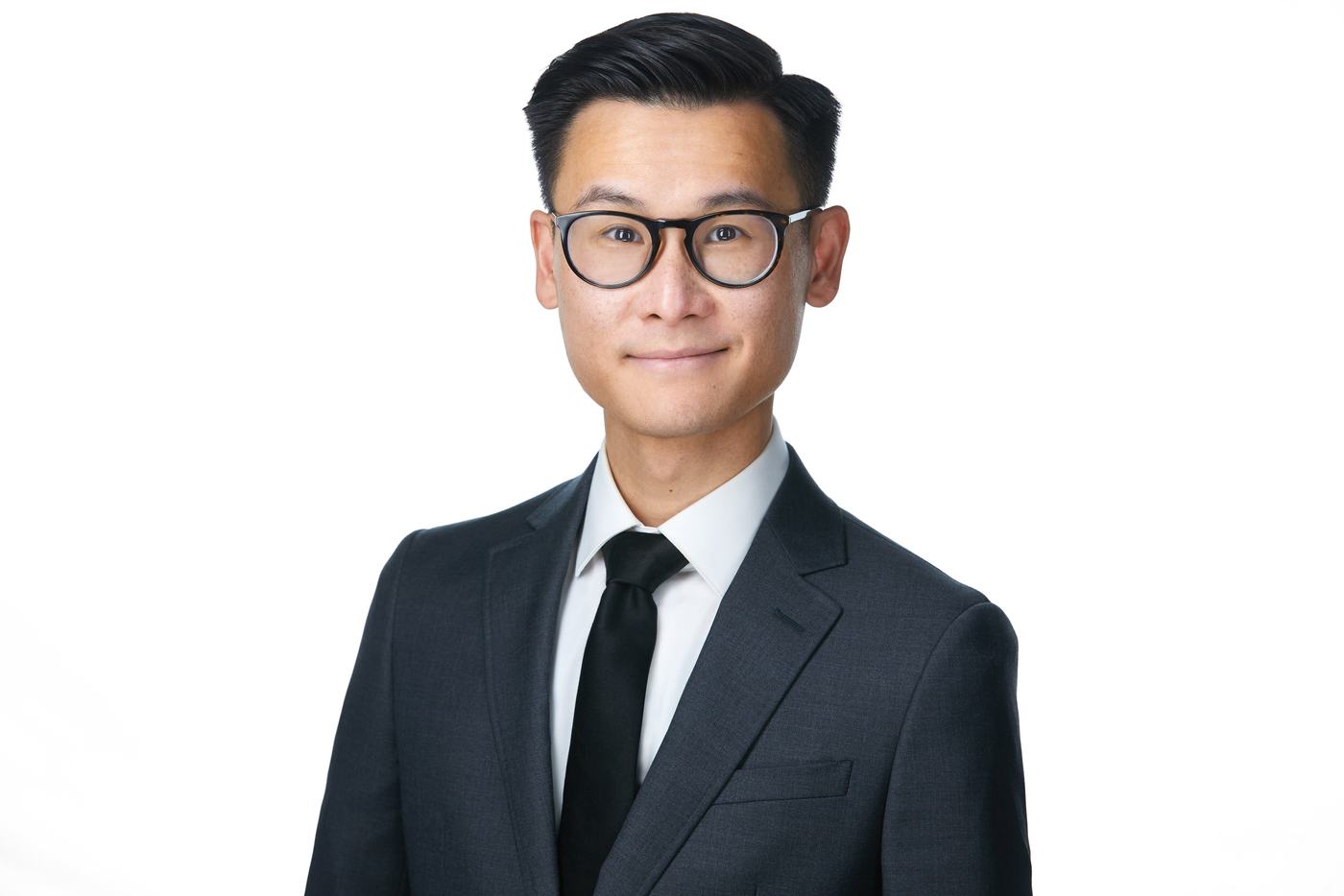 Business headshot on white, a dark suit and glasses