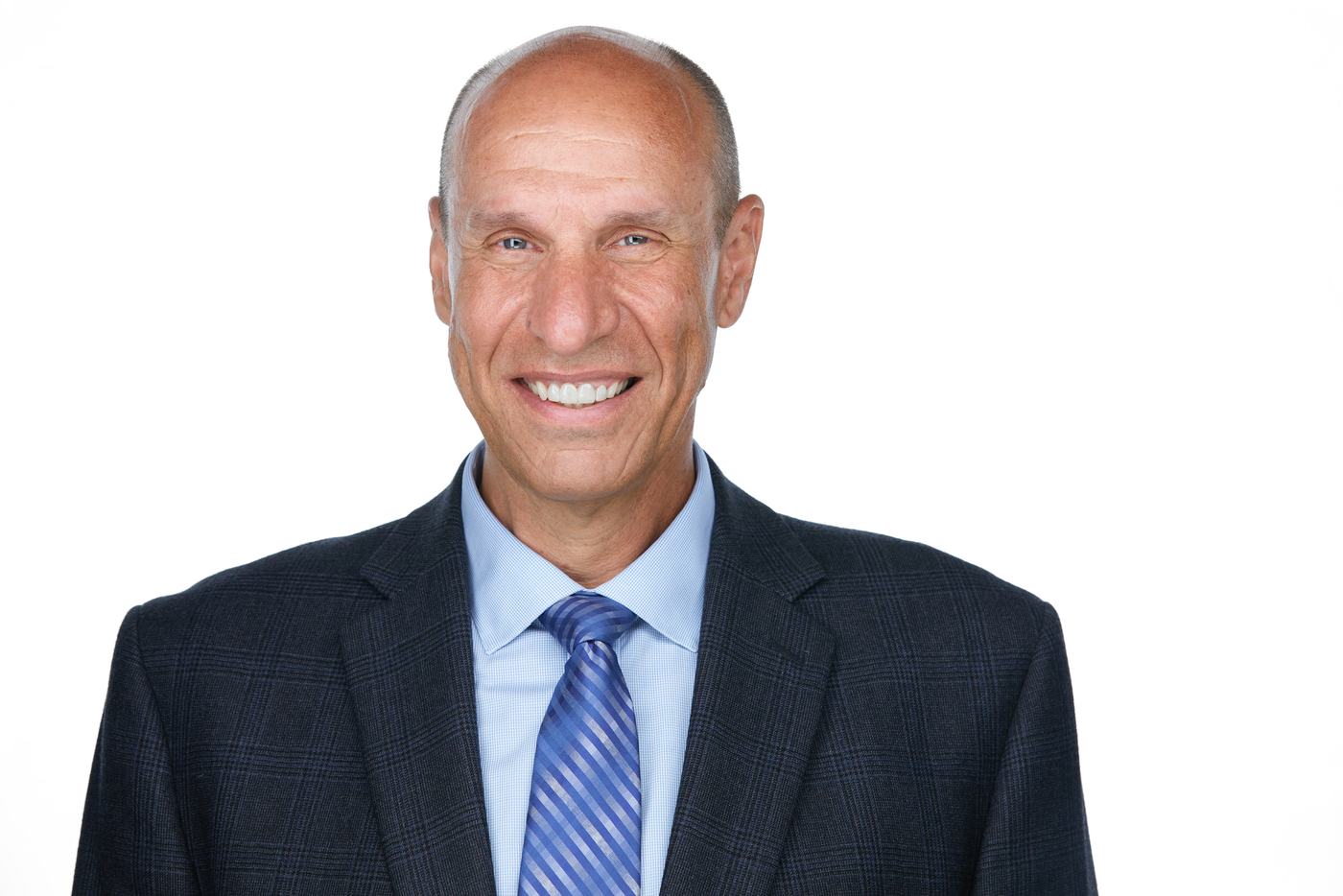 Business headshot on white, a navy suit and blue tie