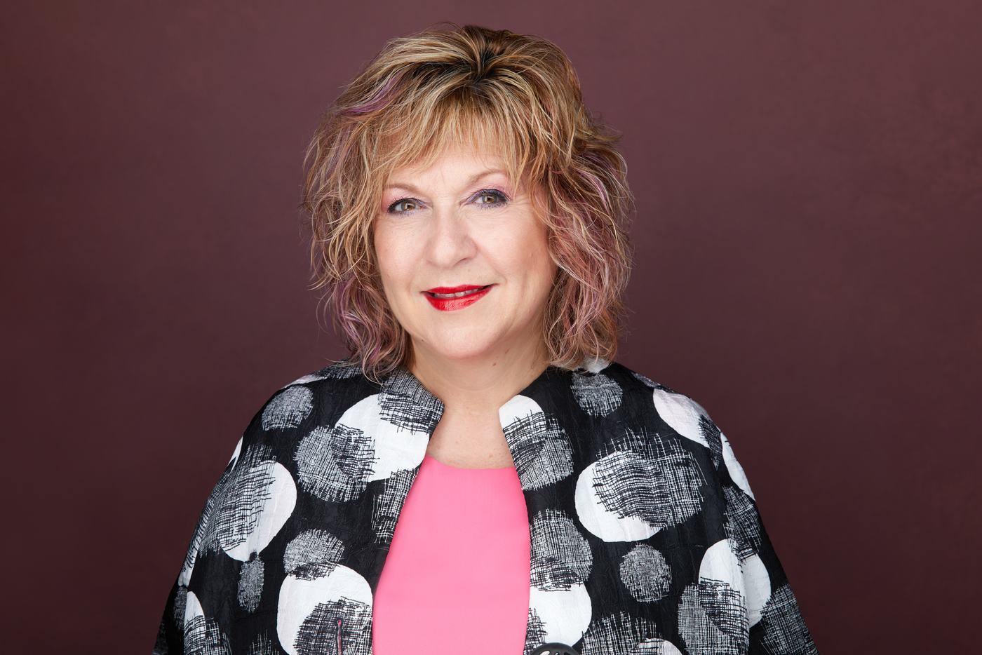 Business headshot on burgundy, a black and white print jacket
