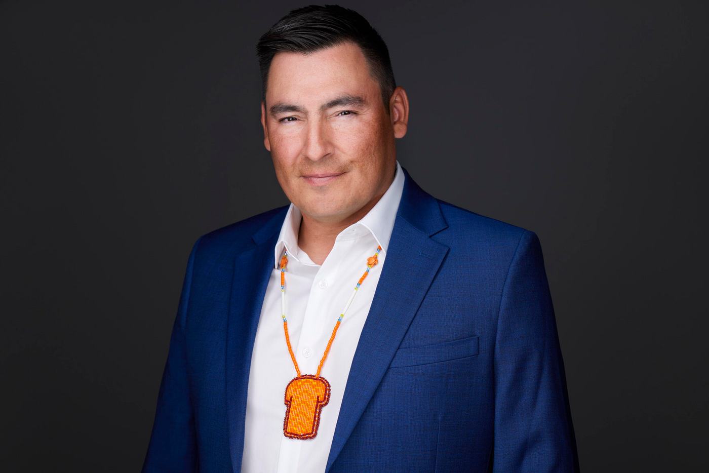 Business headshot, a blue blazer on charcoal