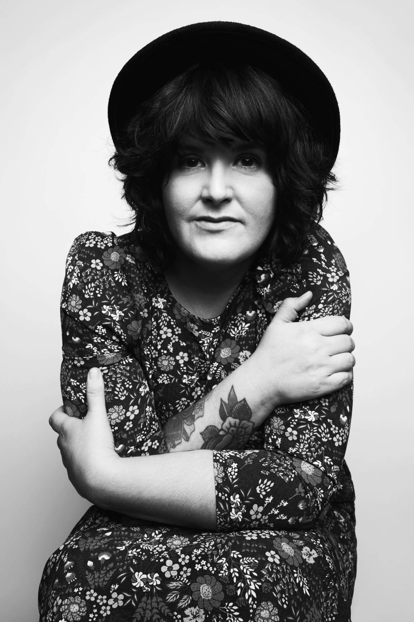 The same session in black and white, arms wrapped around herself