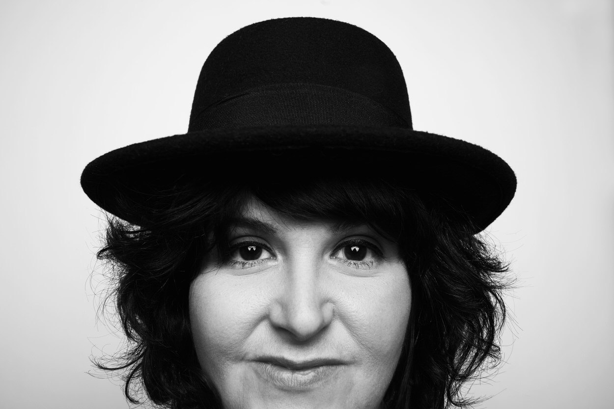The same session, black and white, a slight smile under the hat