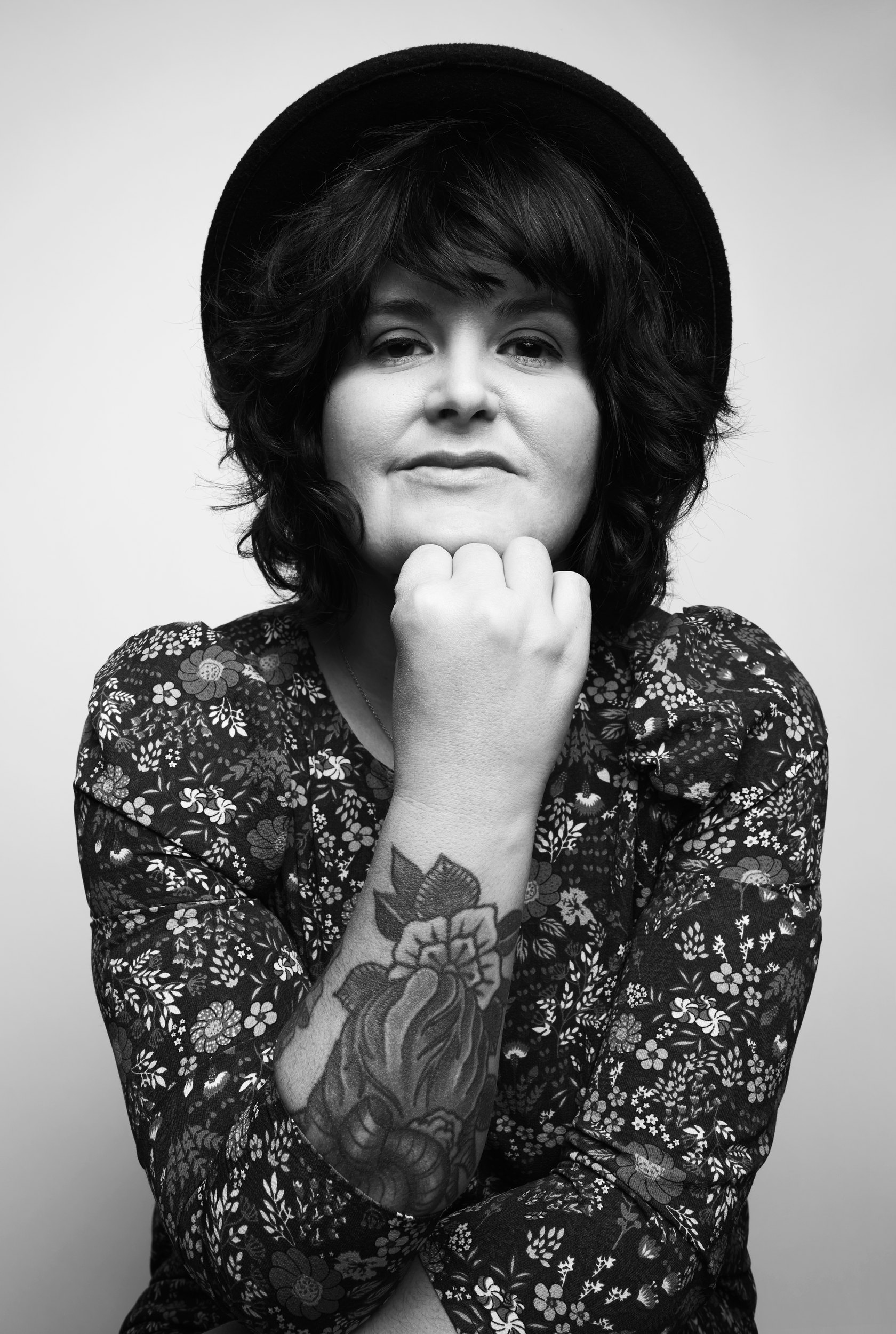The same session, black and white, chin on a tattooed fist