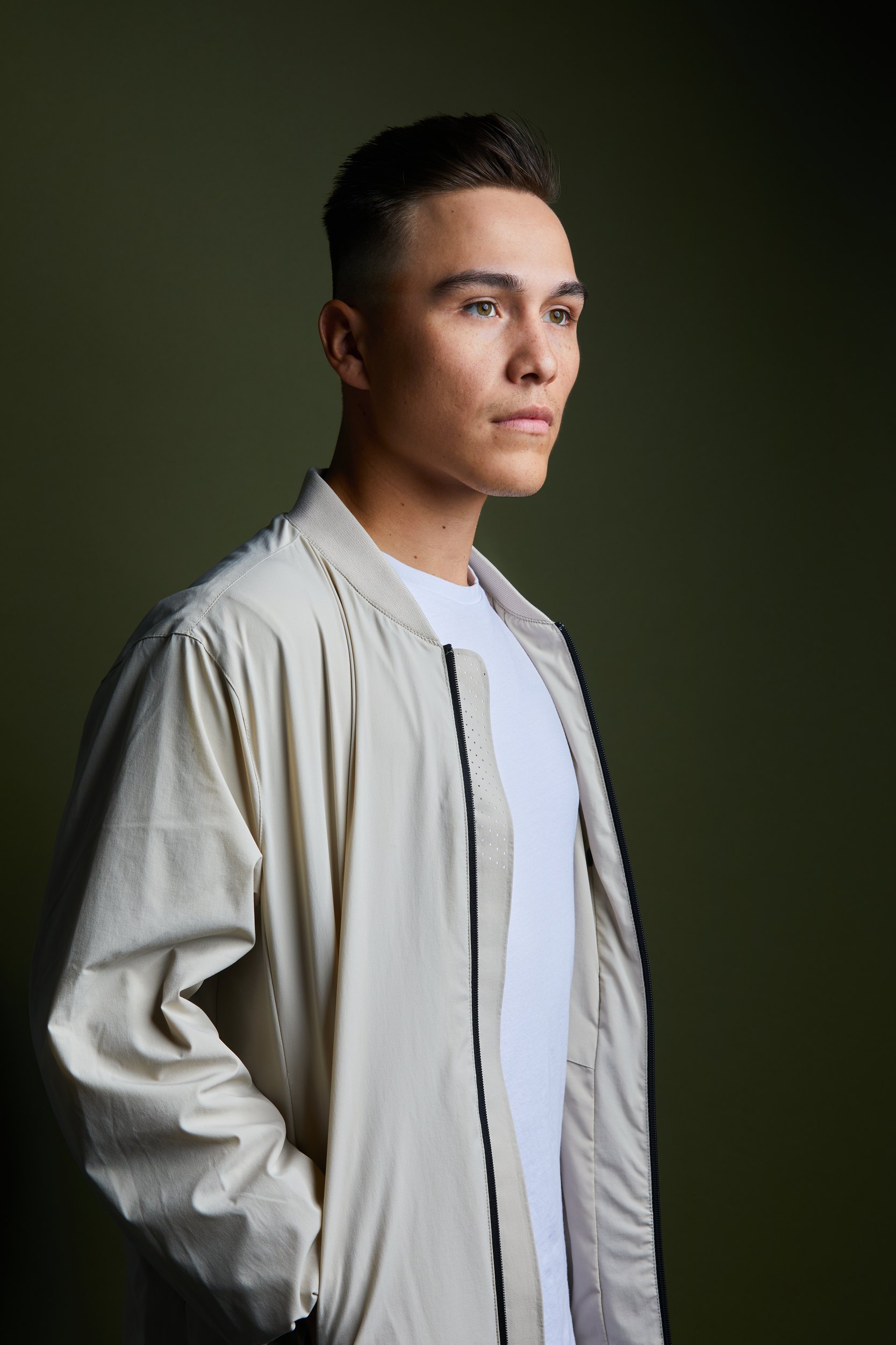The same session, a cream bomber over a white tee against olive
