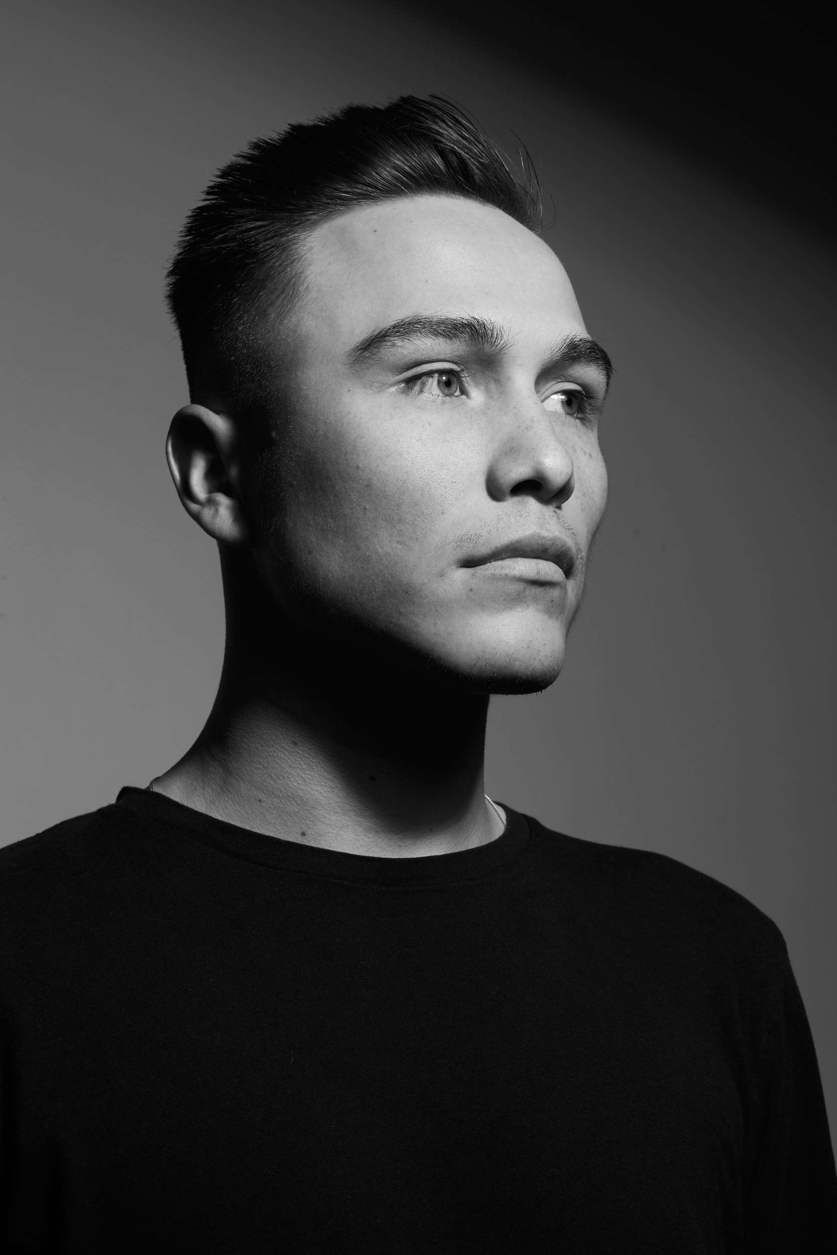 The same session in black and white, the black tee, in profile against grey