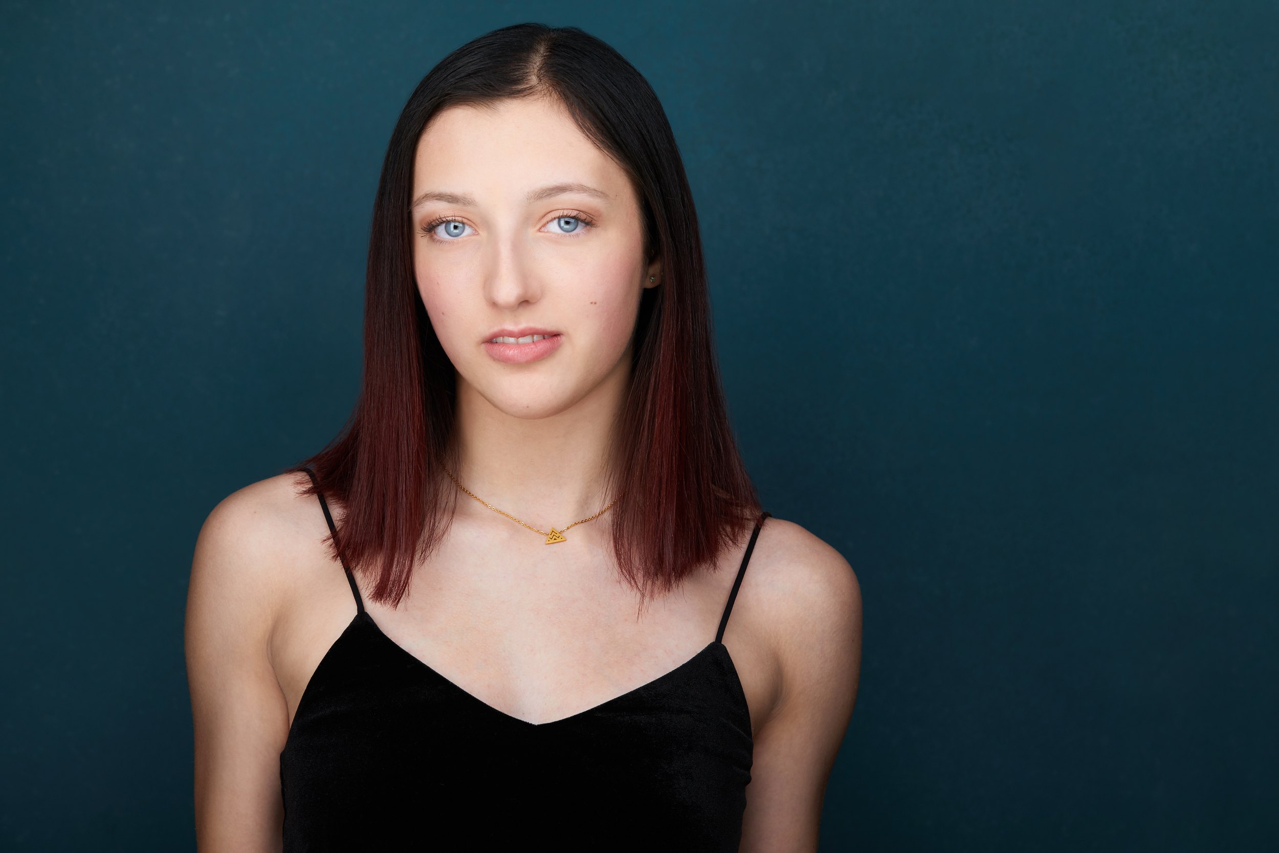 Dance headshot: a black camisole against teal