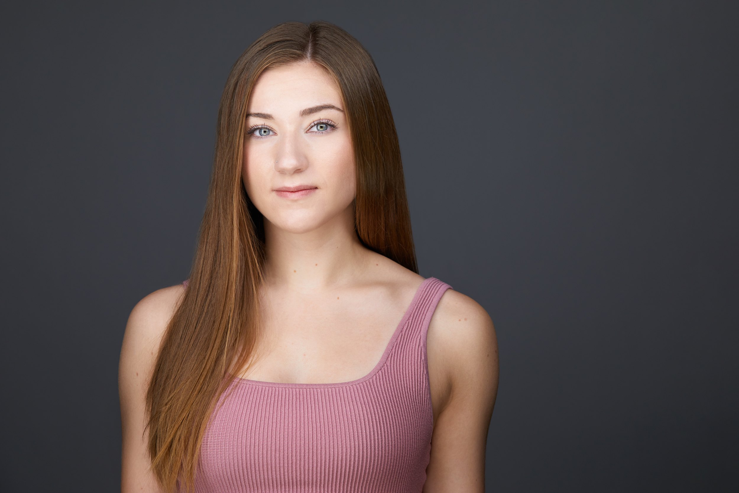 Dance headshot: a pink tank top against grey
