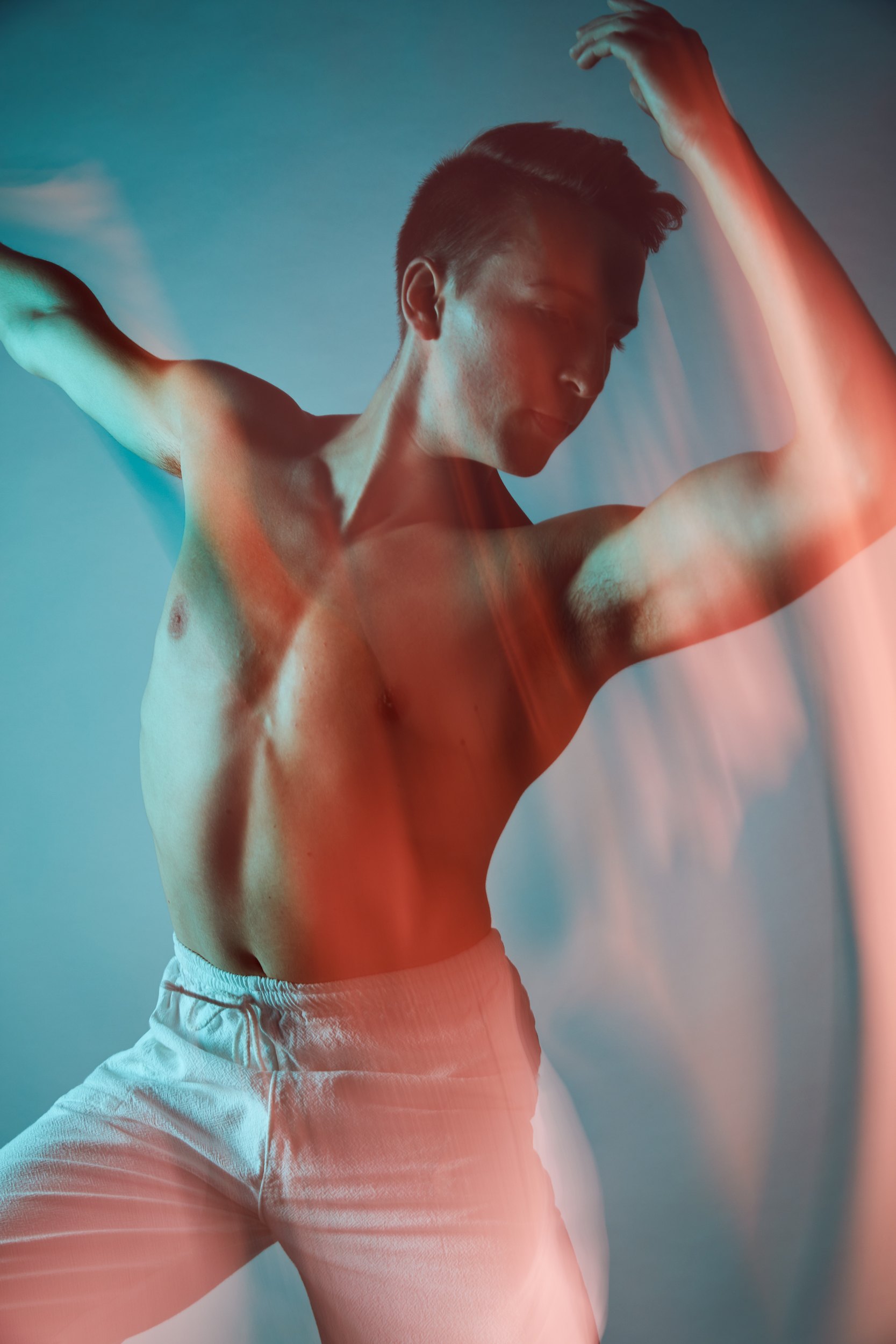 The same gels, arms spread wide, blurred with the move