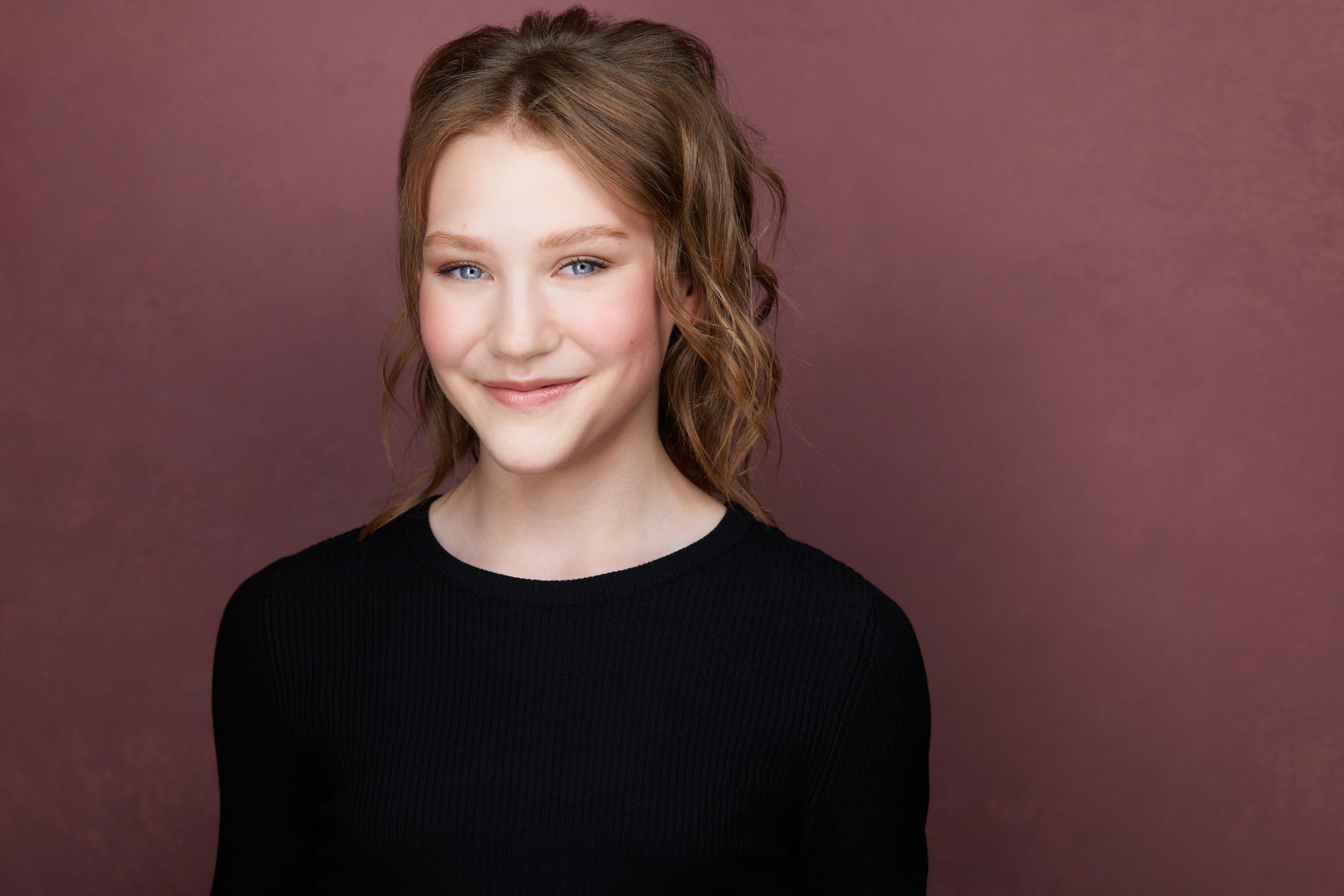 Dance headshot: a black top against mauve