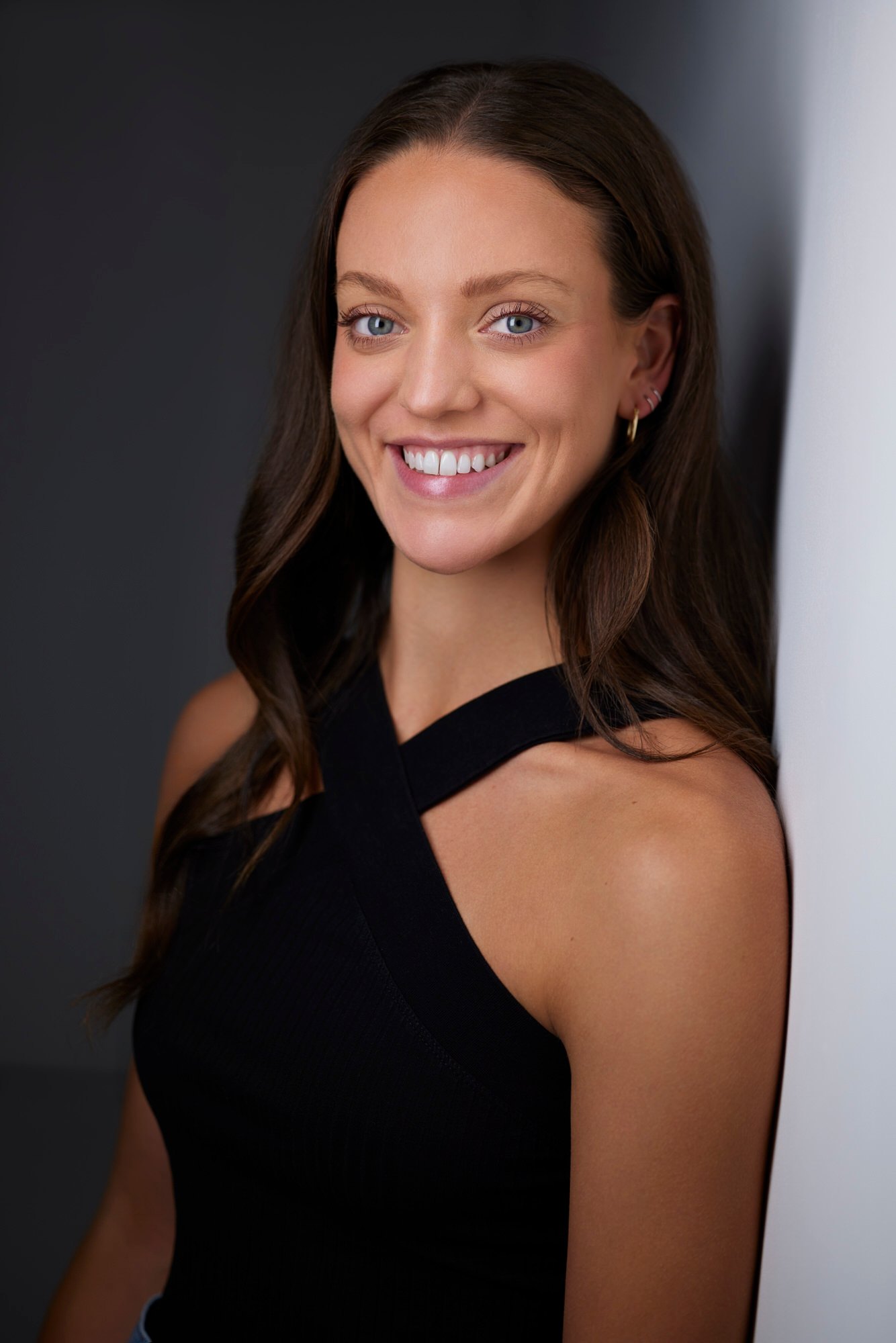 Dance headshot: a black halter against the wall of light