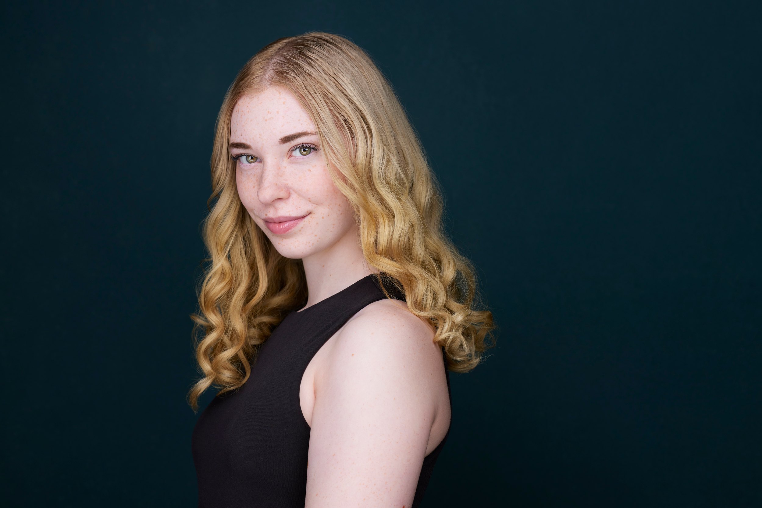 Dance headshot: a black halter against teal