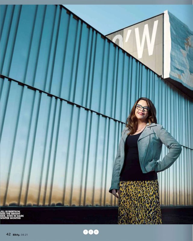 The printed page: a woman in a grey-green jacket and a leopard-print skirt against a blue corrugated wall, the story set beneath