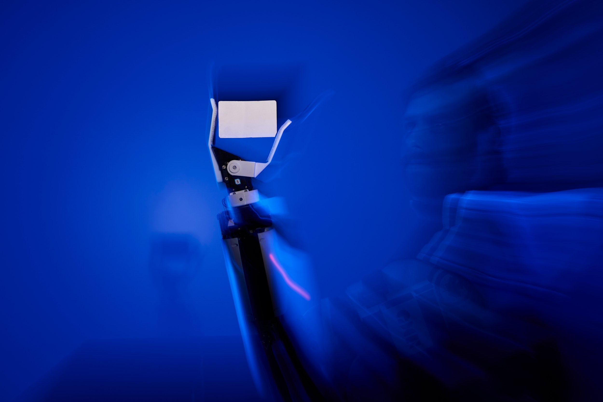 The gripper in deep blue, moving, almost abstract