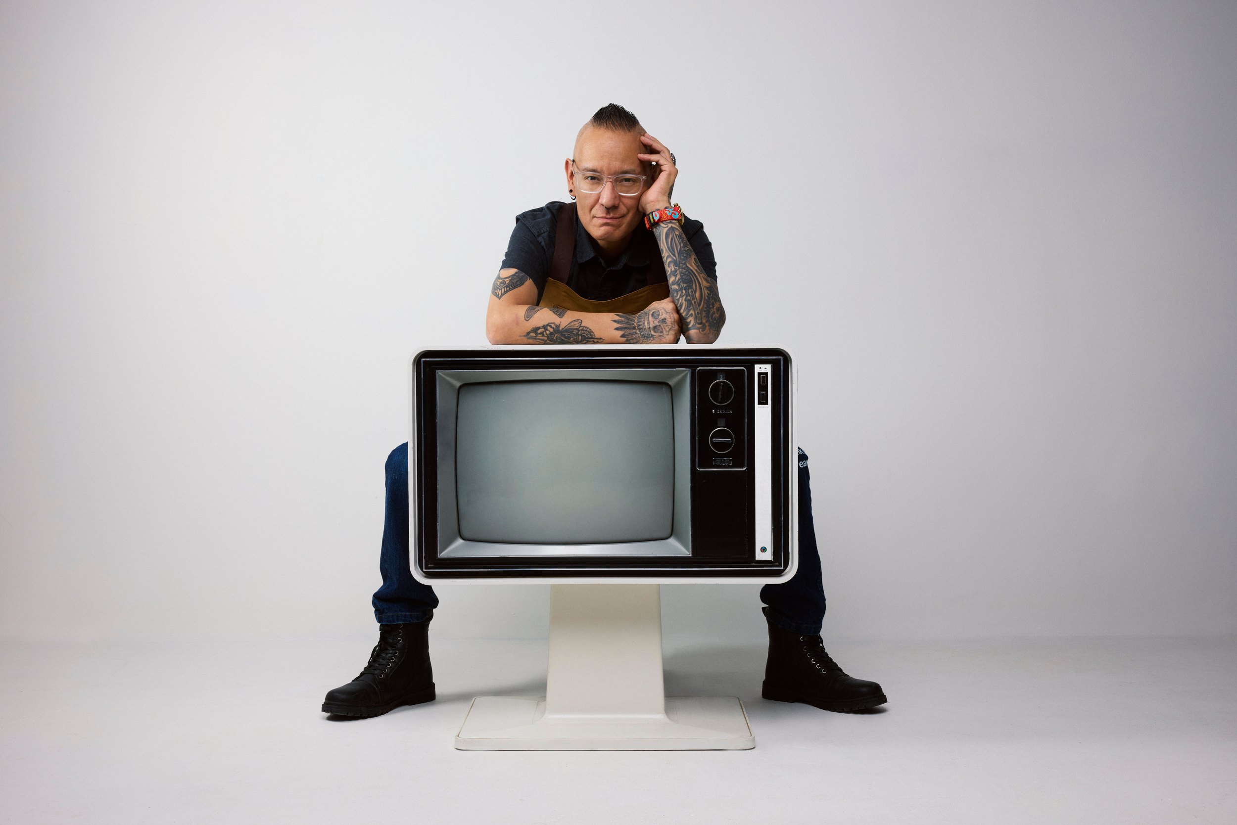 At the counter, arms crossed in front of him