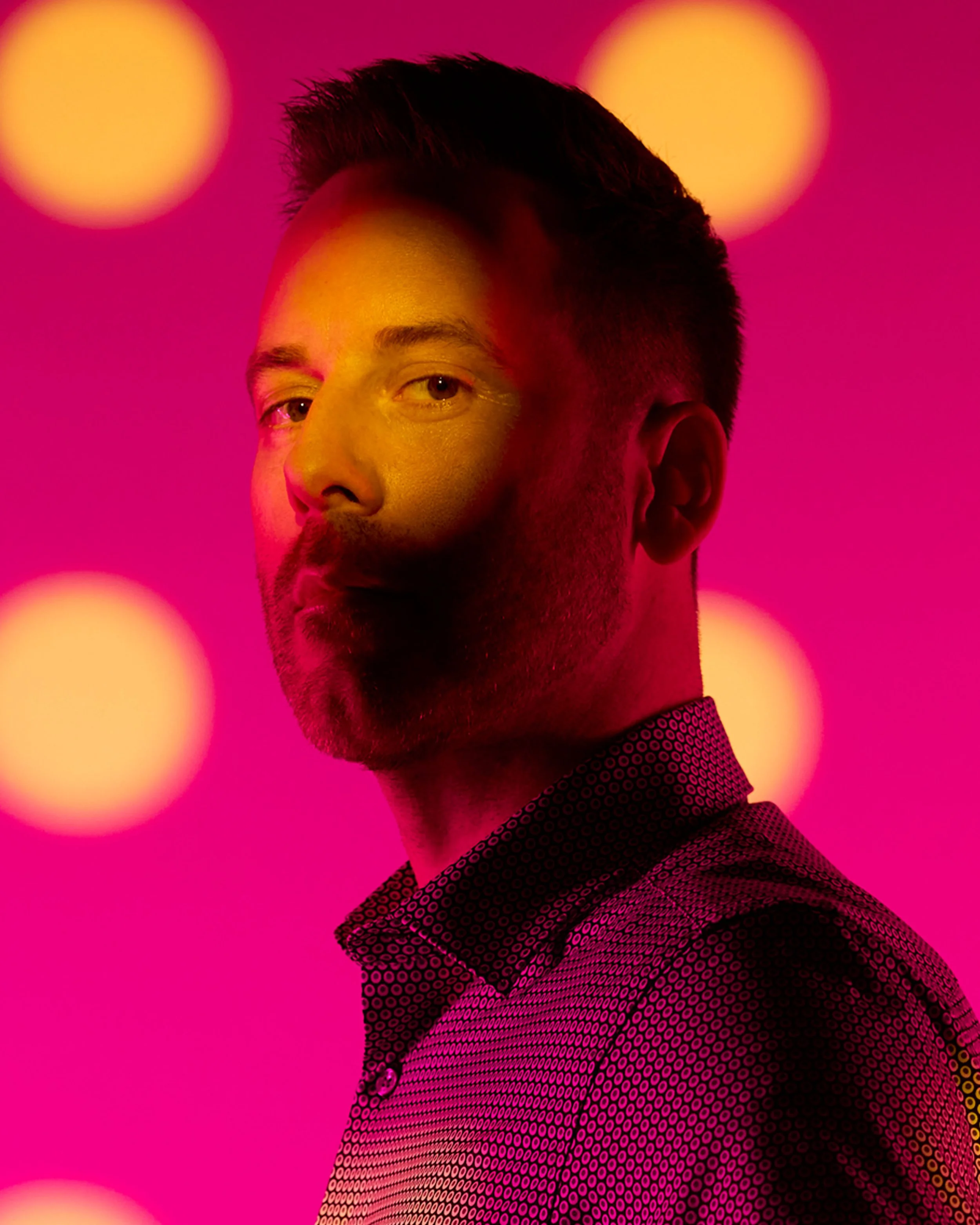 The frame itself: a man with a beard, lit through a punched card in pink and yellow
