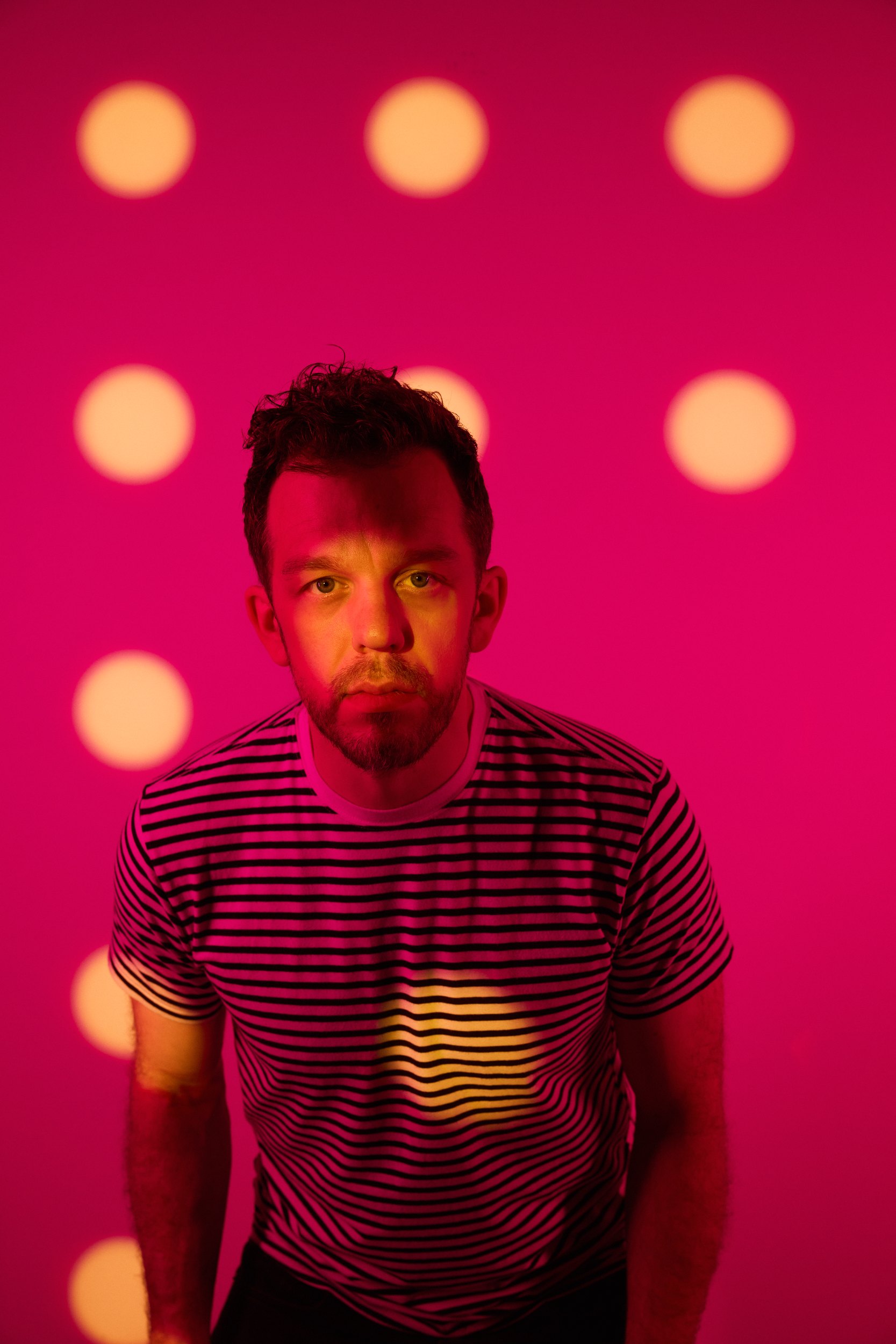The cover frame: head and shoulders, a striped shirt, the dots falling across him