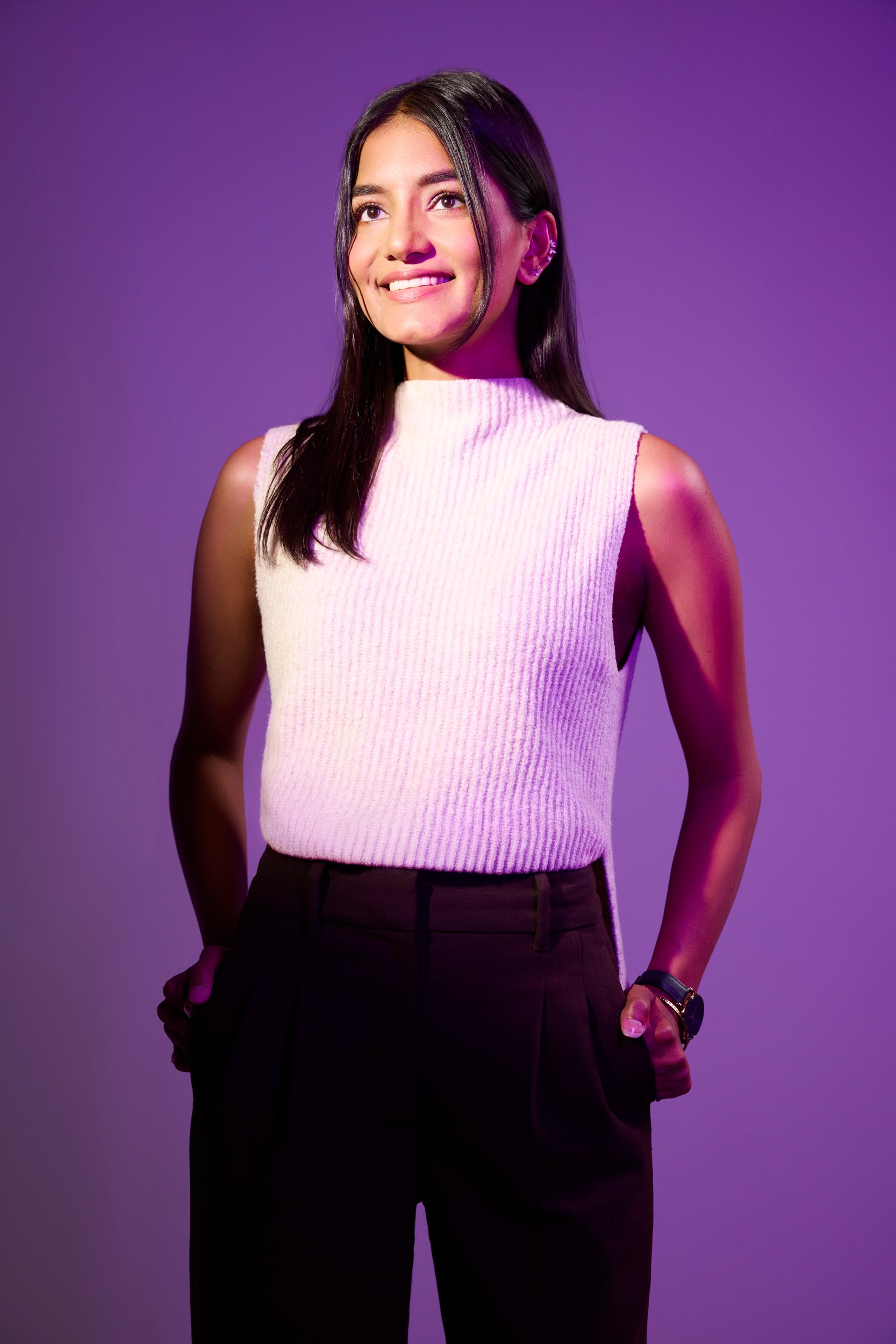 Jaanek Grewal in a pale sleeveless top against violet