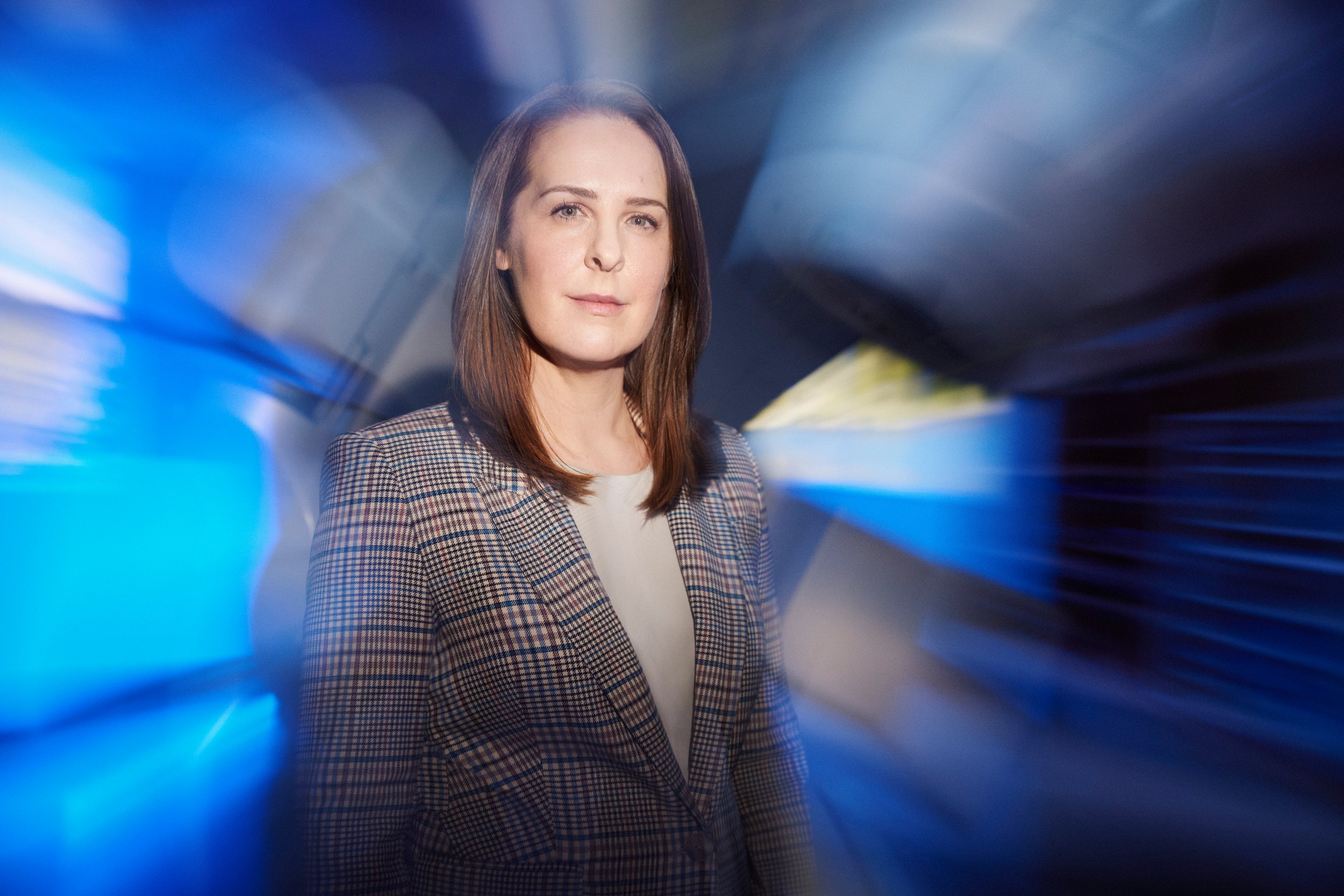 The frame that ran on the cover: the physician in a checked blazer, the imaging suite lit blue behind her