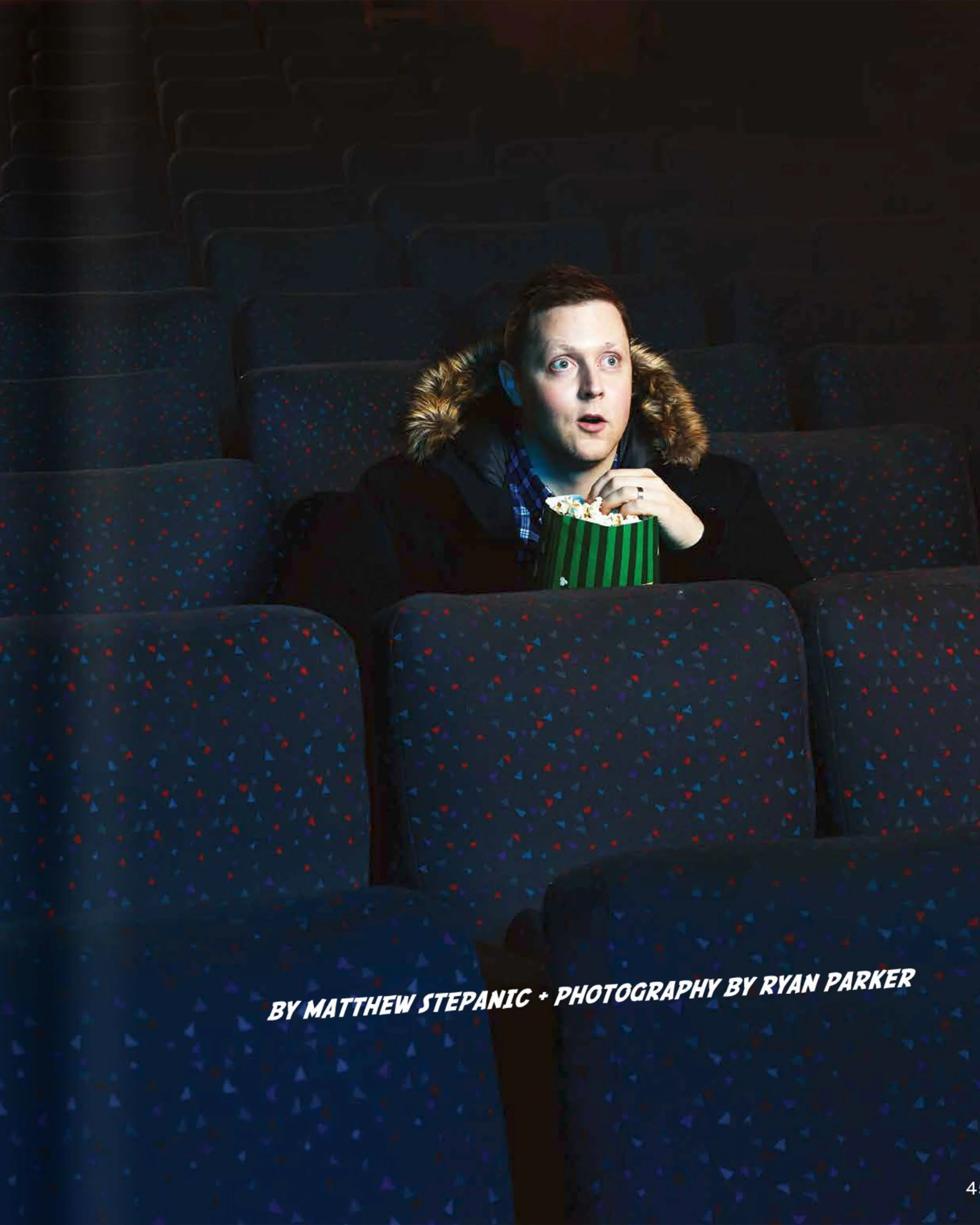 The printed page: Kurt McLeod in a theatre seat with a box of popcorn, the rows empty around him