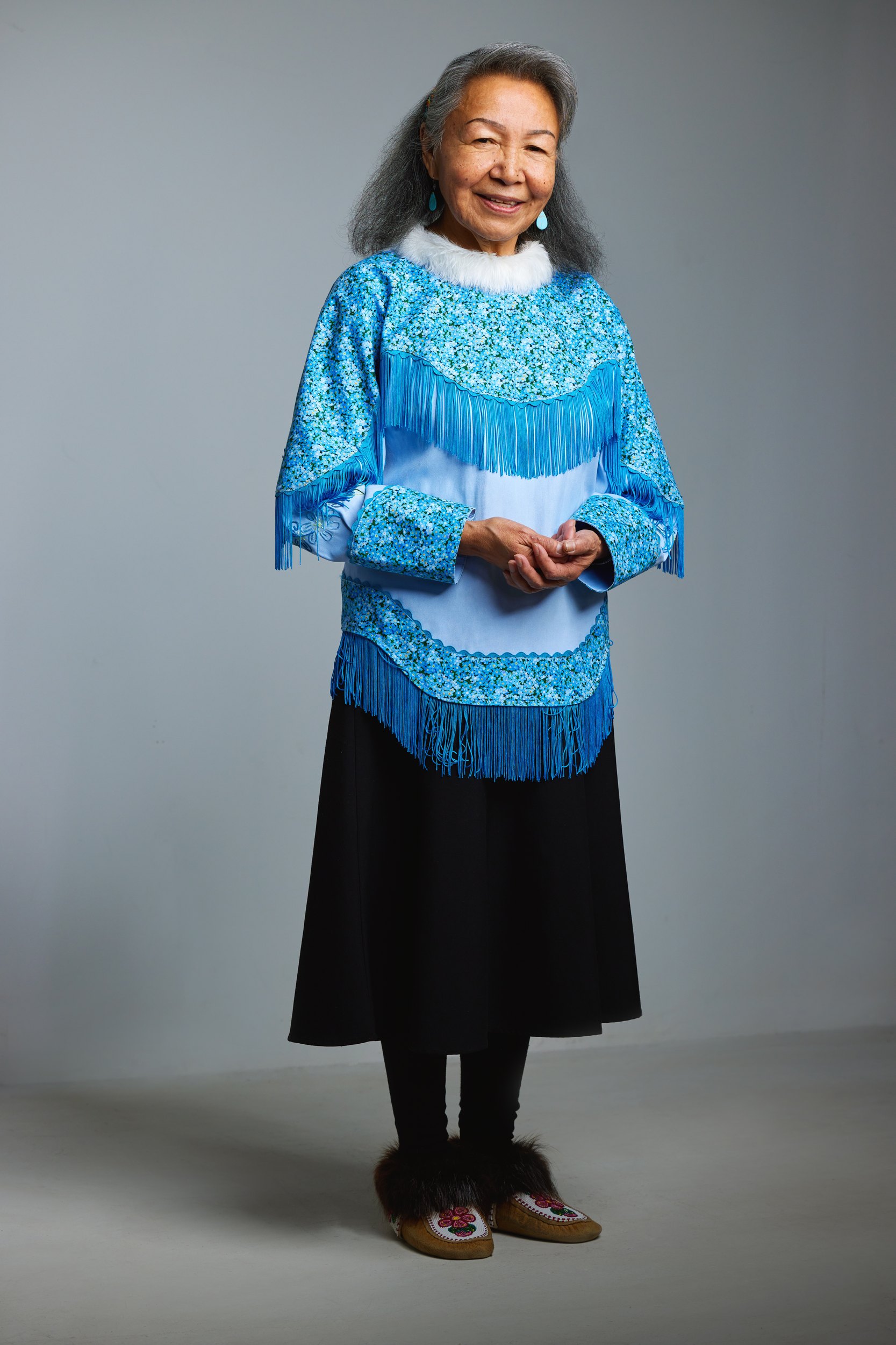 Leadership portrait: a blue beaded dress, standing, full length