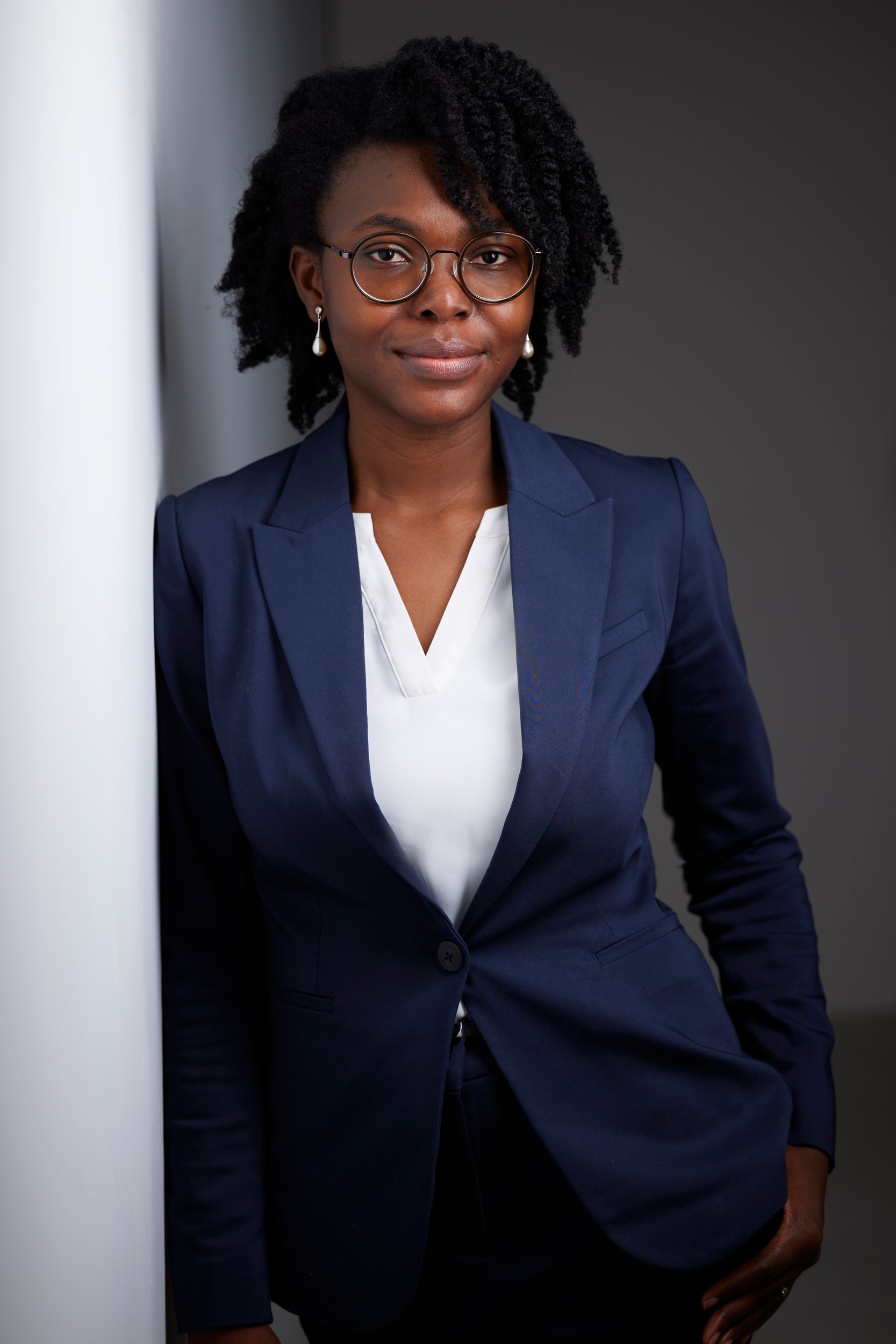 The same session: a navy blazer against a wall of light