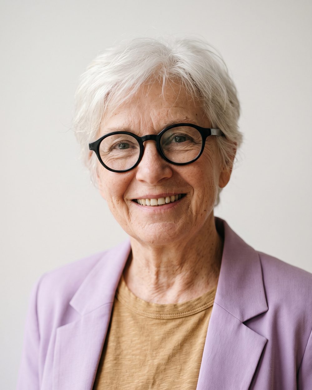 AI-generated face: a smiling older woman with short white hair and round black glasses, in a lilac blazer, against a white background