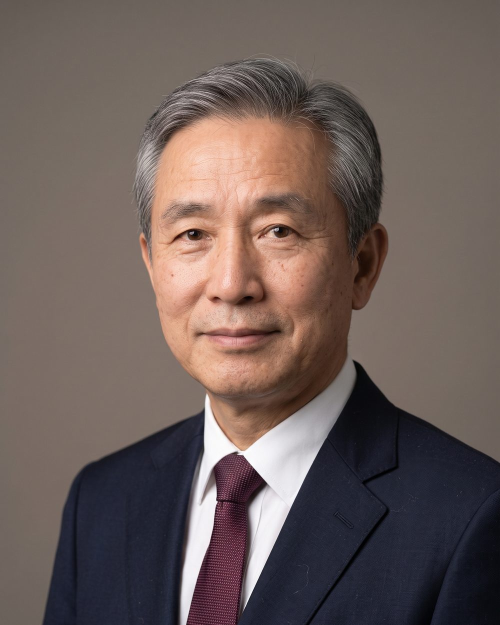 AI-generated face: an older man with grey hair in a navy suit, white shirt and dark red tie, against a grey background