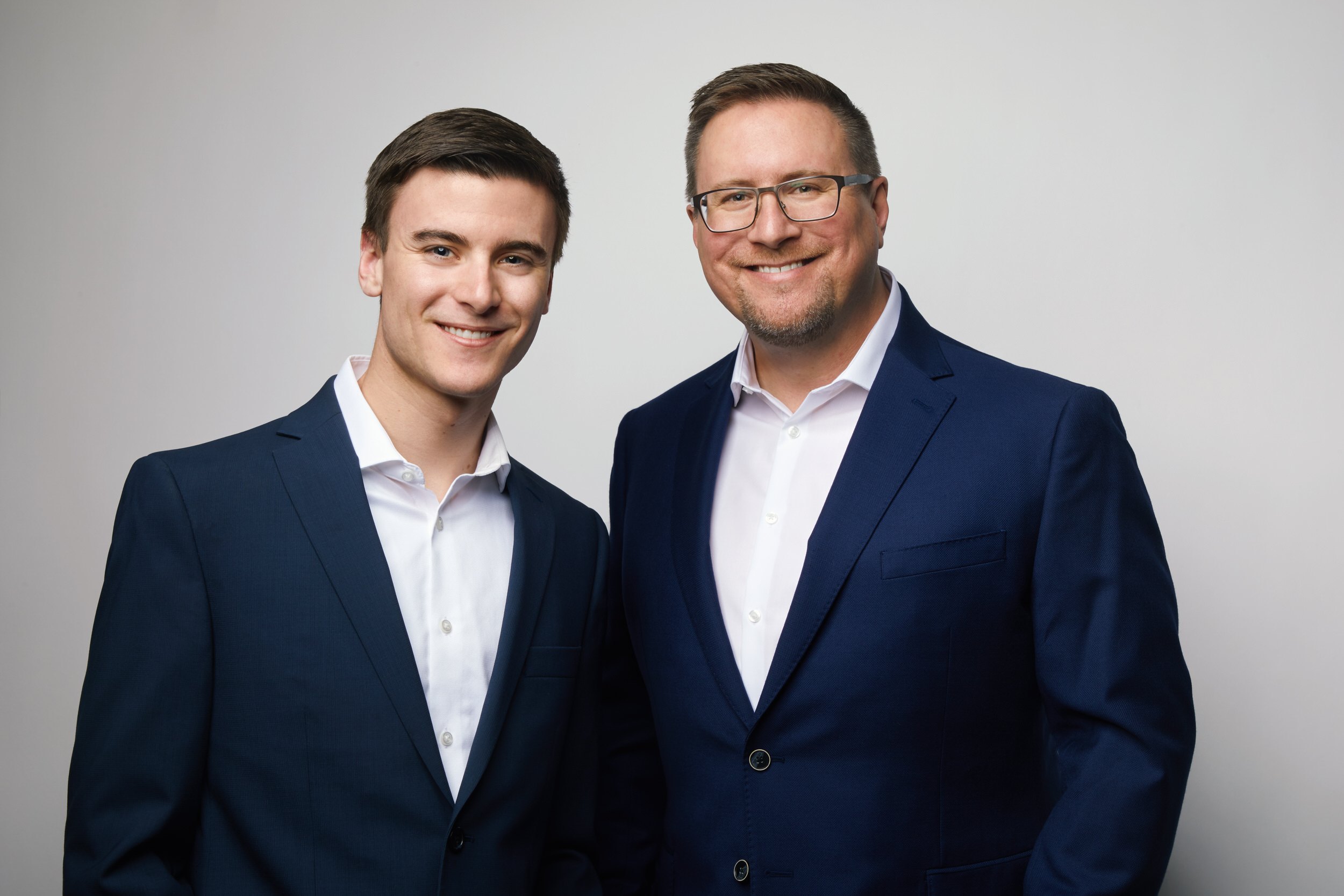 Two partners in navy suits on white, Edmonton studio