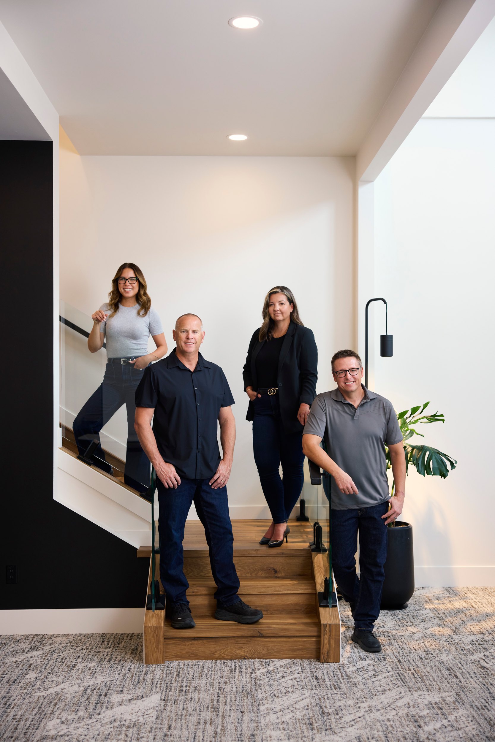 Group photo of a five-person team on the stairs in their own office, Edmonton