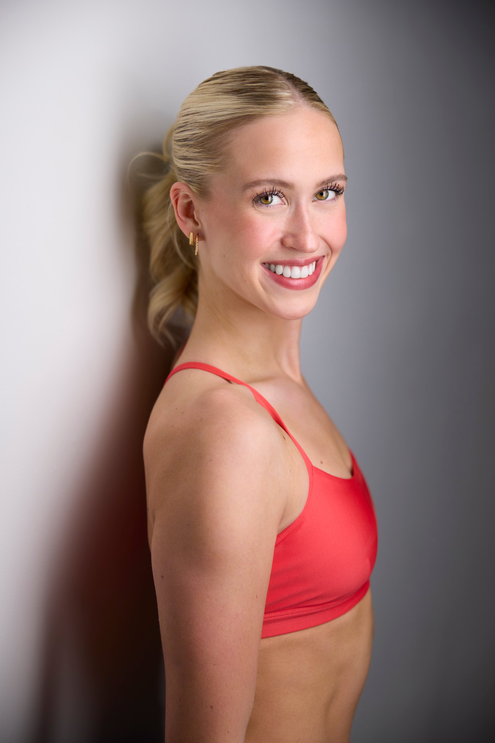 The same session, orange against a wall of light, hair up