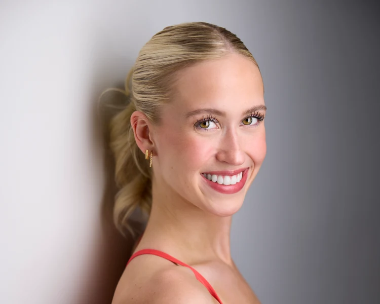 The same session, orange against a wall of light, hair up