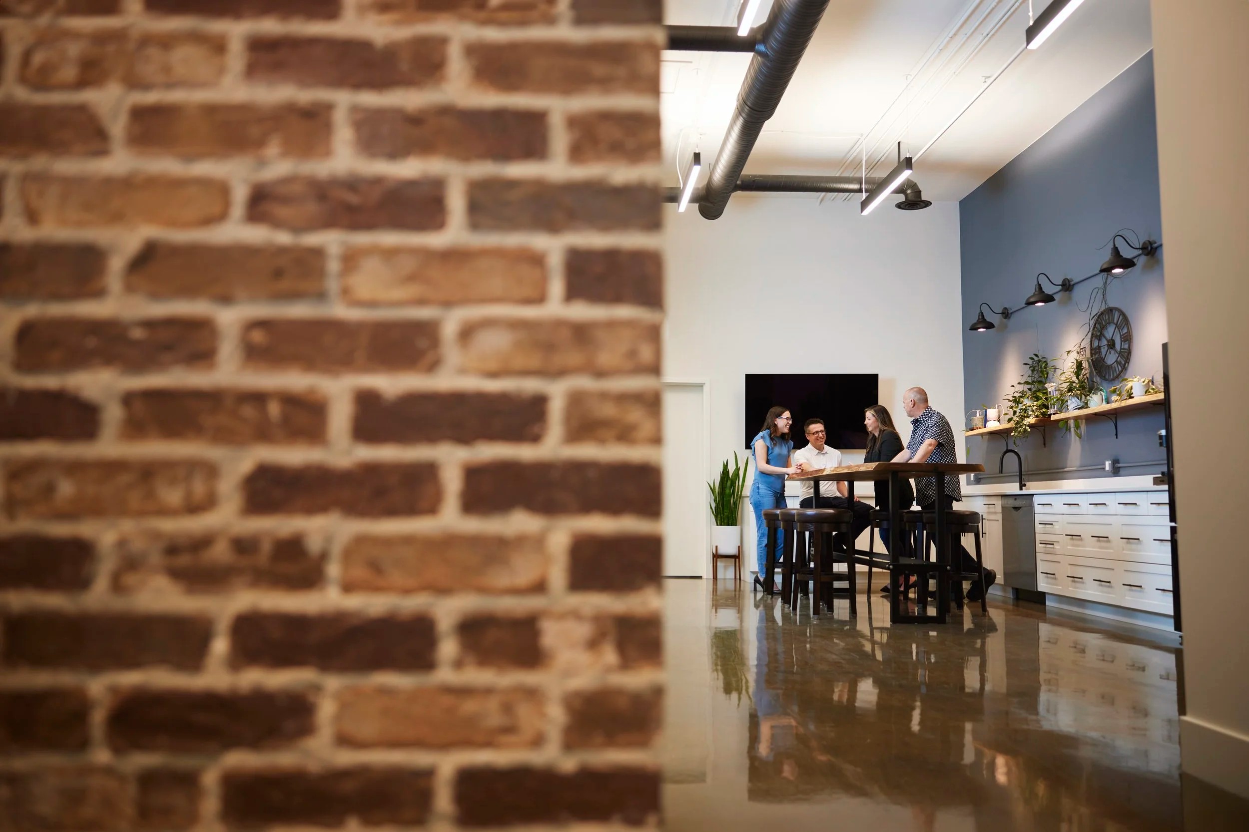 A real estate team at their front desk, brick wall and all