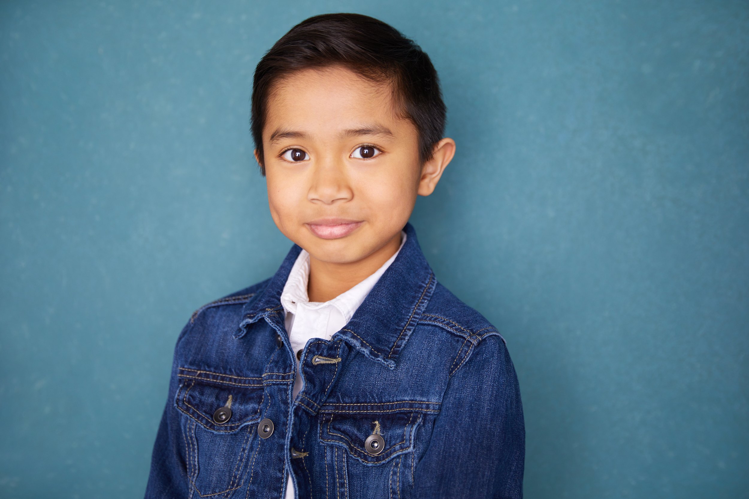 Kids and teens headshot: a denim jacket over a white shirt against blue