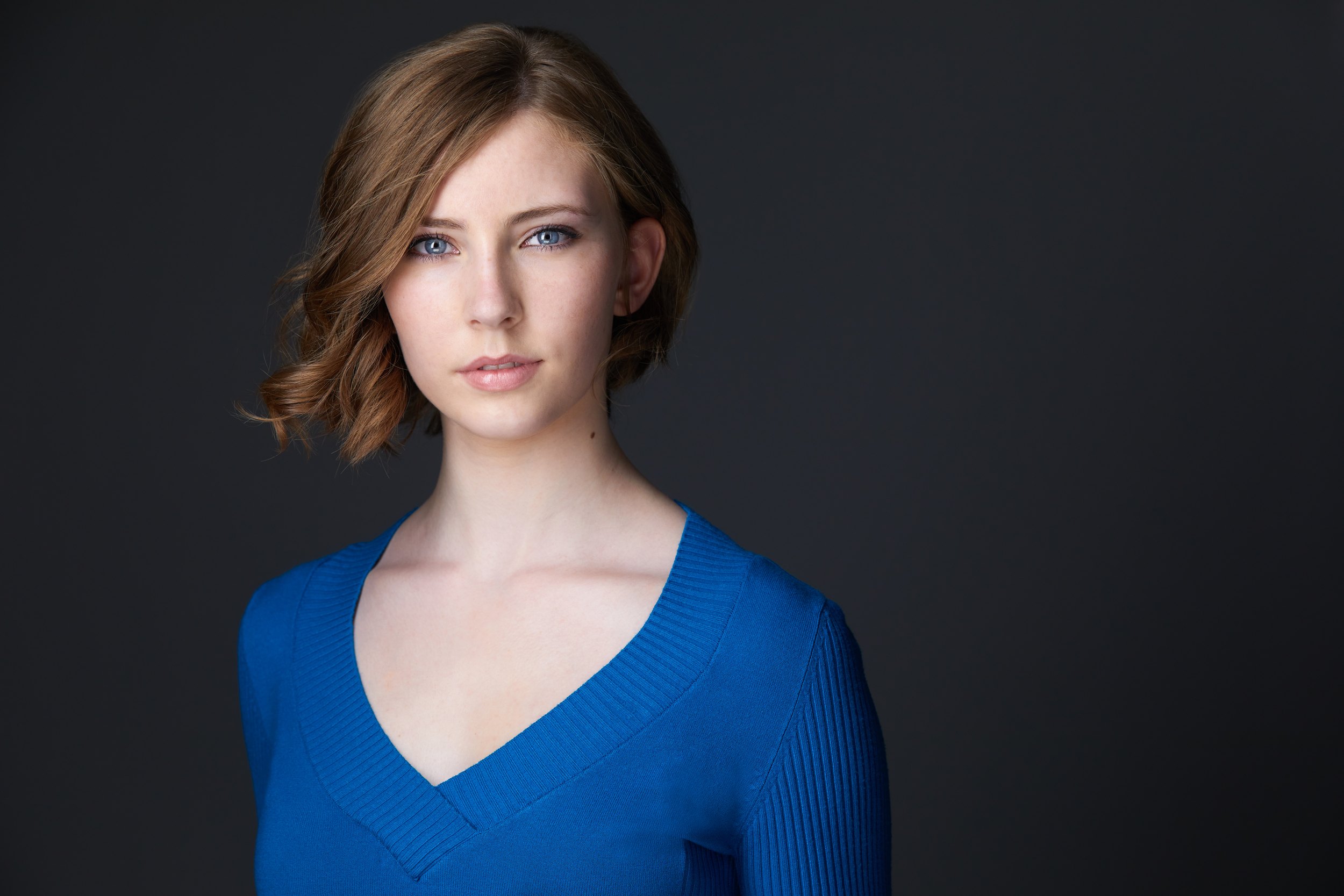 Kids and teens headshot: a blue V-neck against grey