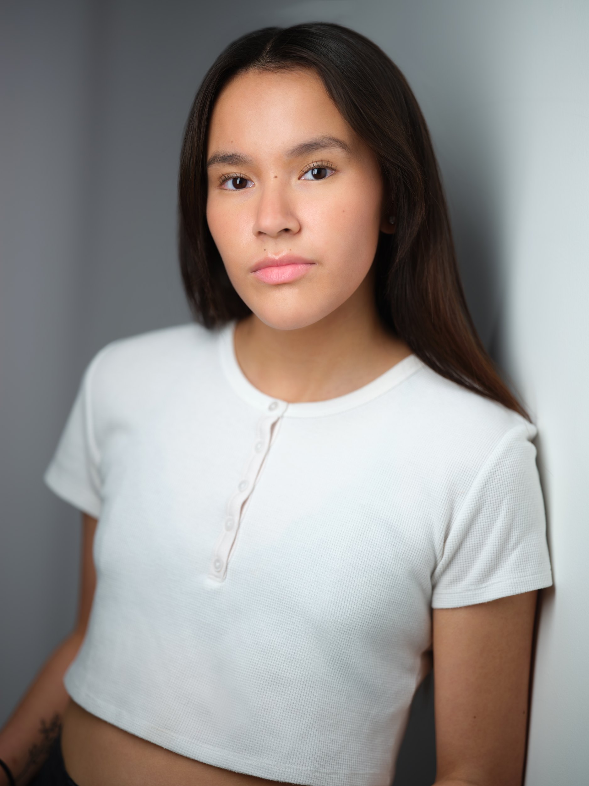 Kids and teens headshot: a white tee against the wall of light, dark hair down