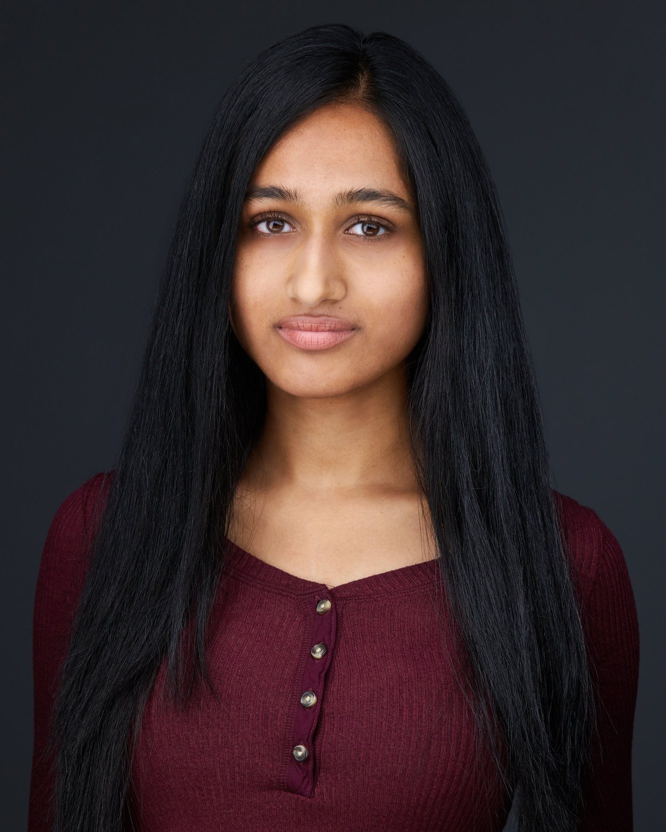 Kids and teens headshot: a maroon henley against charcoal, long dark hair