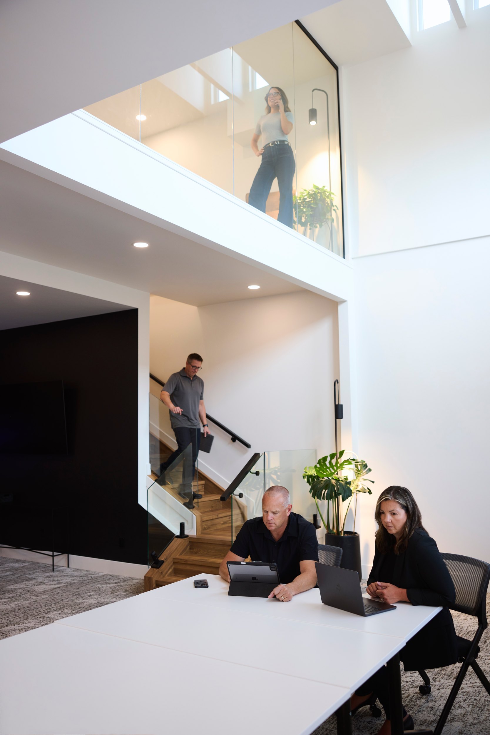 A real estate team at a table under their stairs