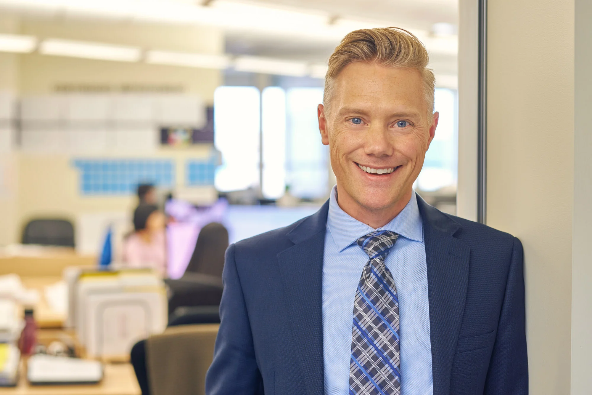 Office portrait at a desk, blue suit and tie